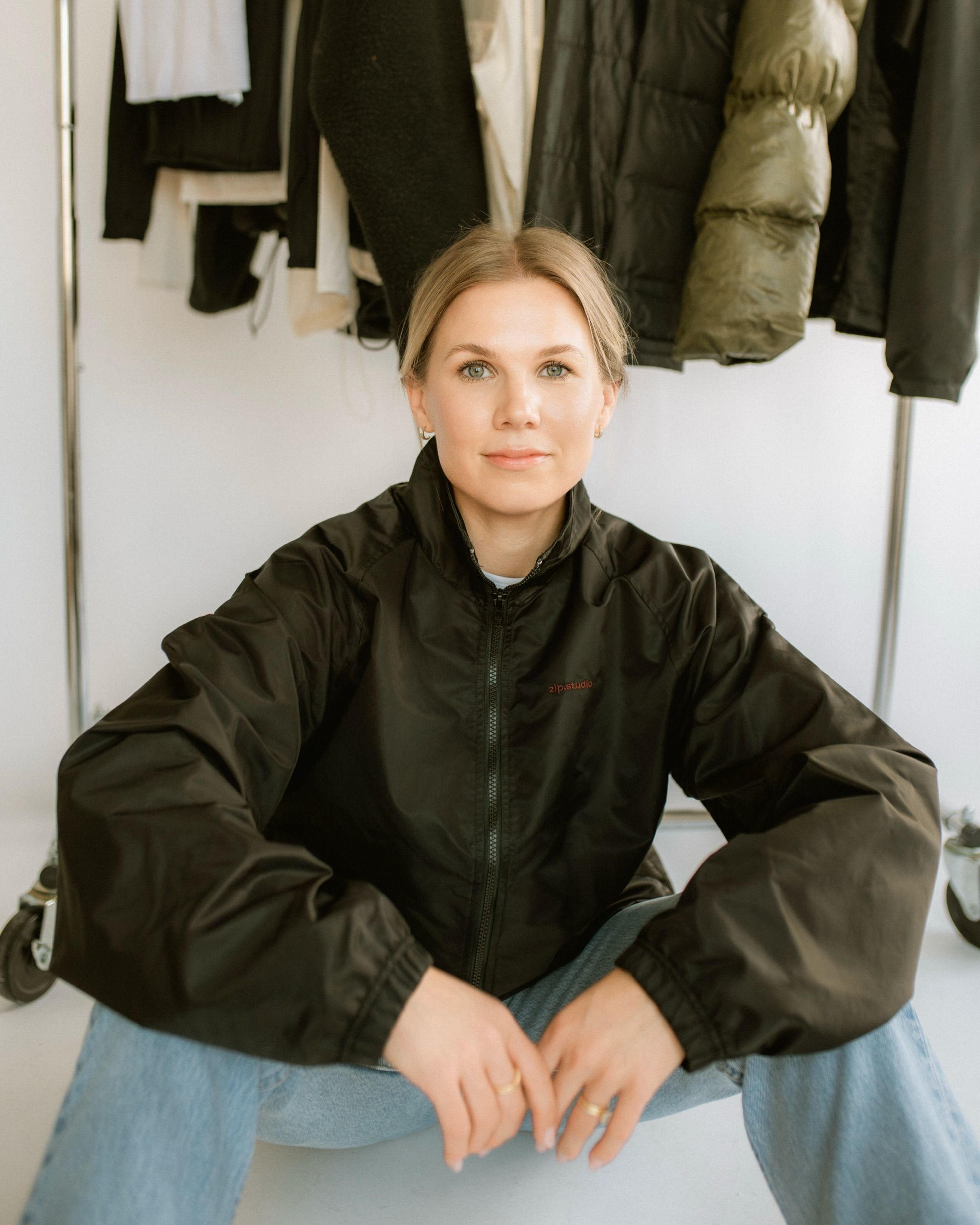 Studio headshot of a woman in a black jacket, seated and relaxed