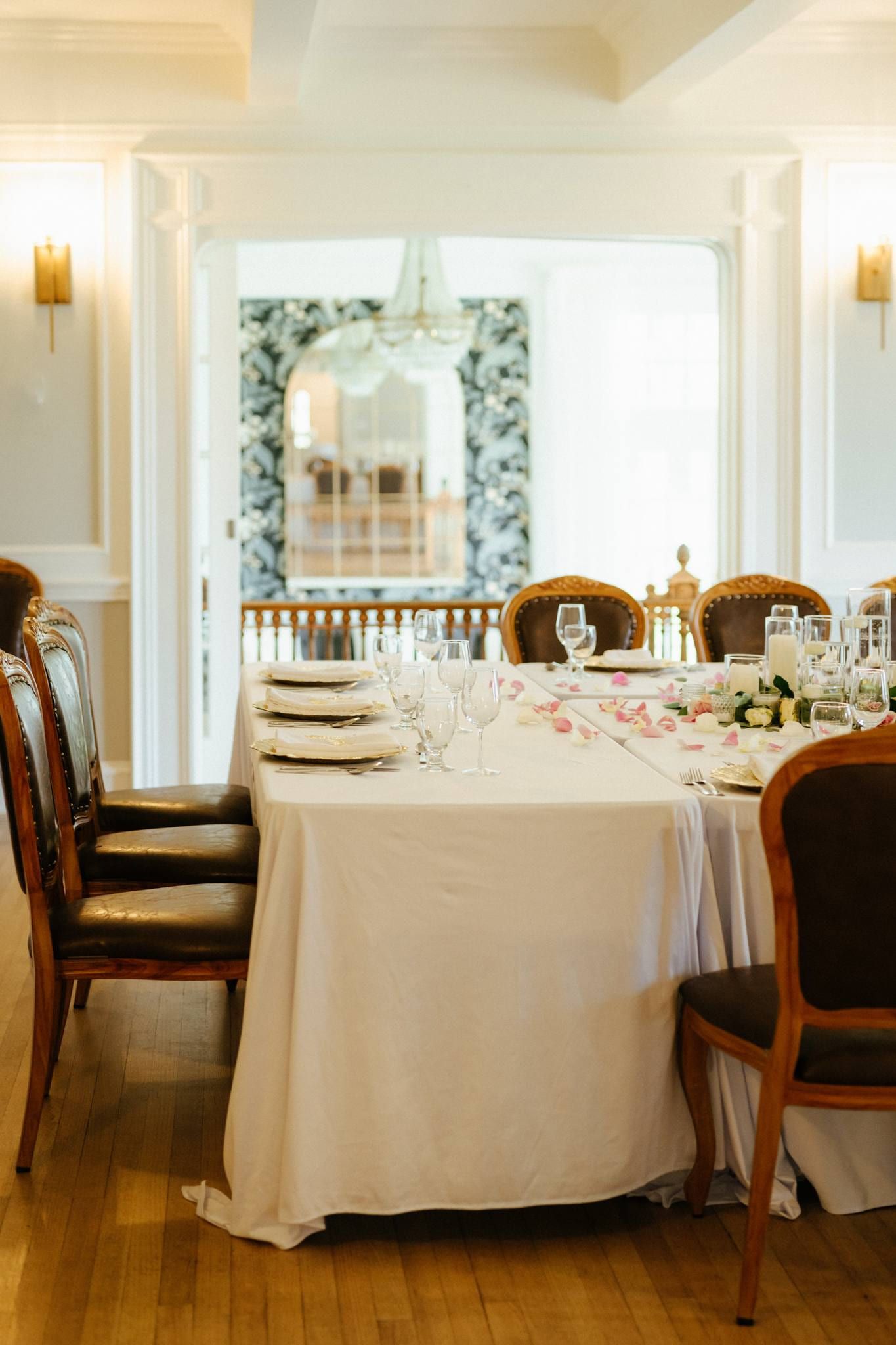Reception table set with white linens and blue plates in a bright dining room