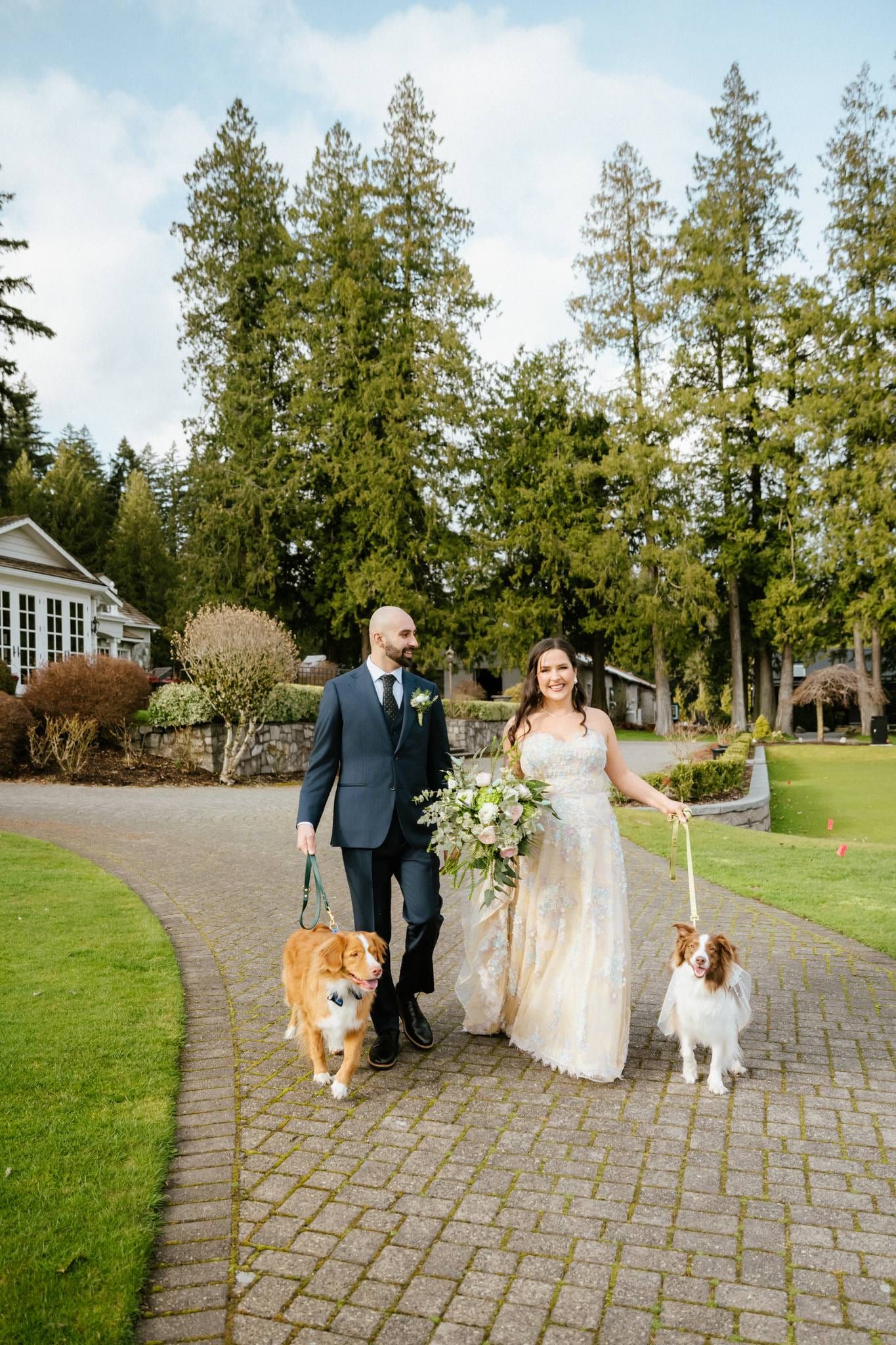 Couple walking a garden path with their two dogs on leads
