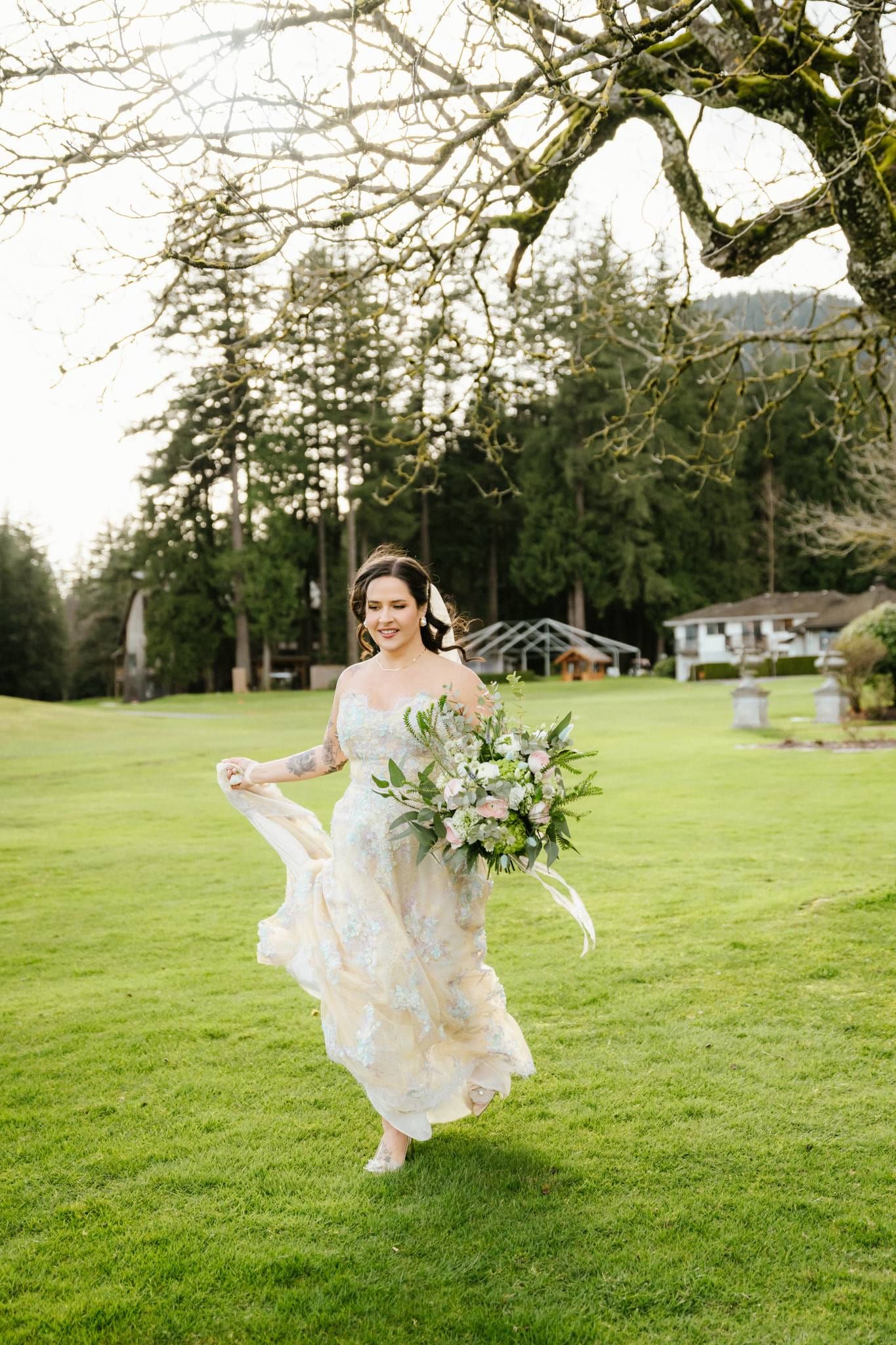 Bride walking across the lawn with her bouquet, the lodge behind her