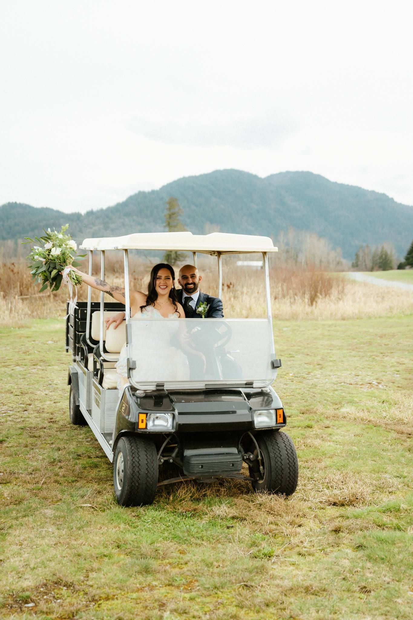 Couple in a golf cart on the lawn with mountains behind