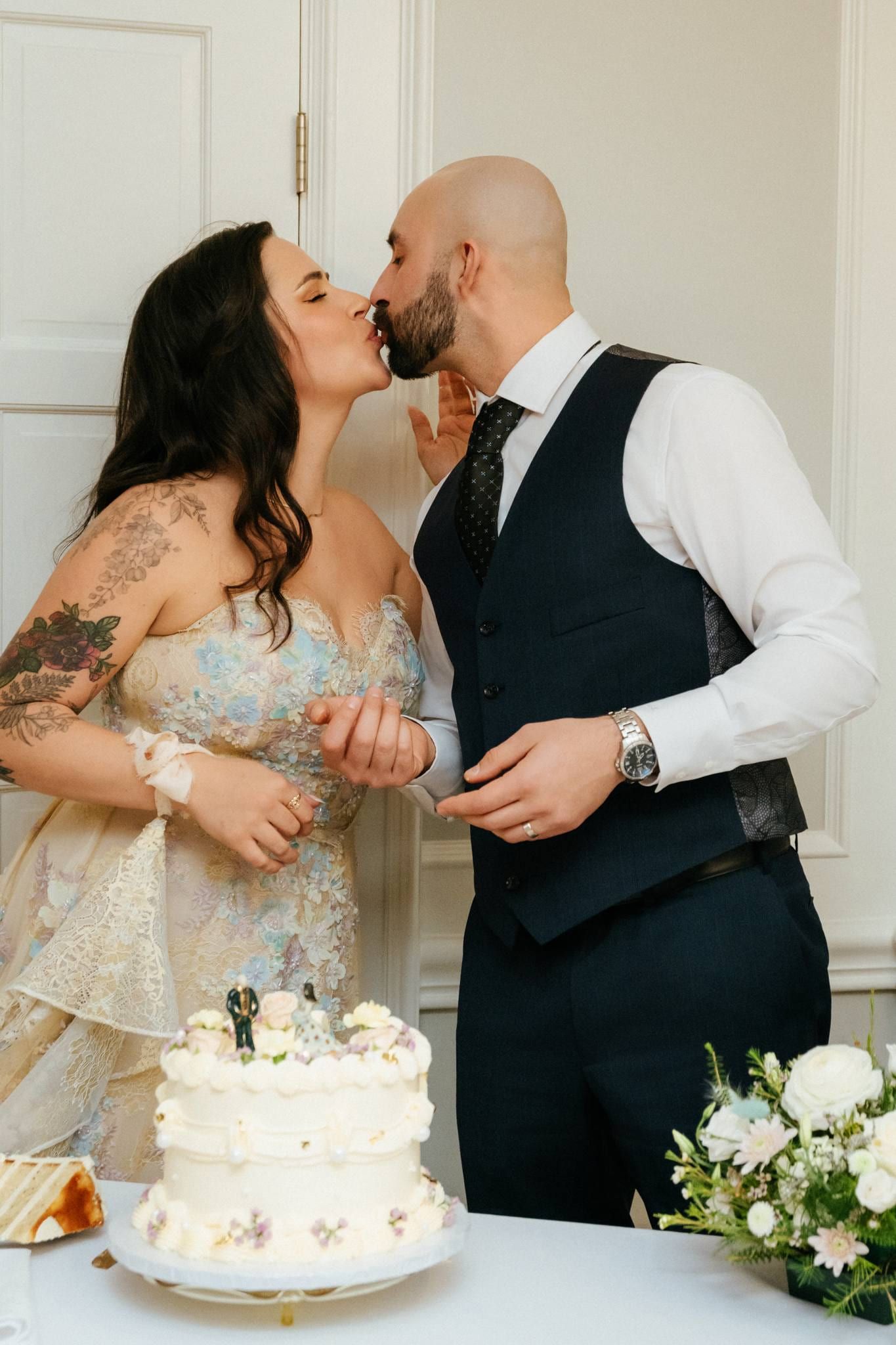 Bride and groom cutting their wedding cake in a bright room