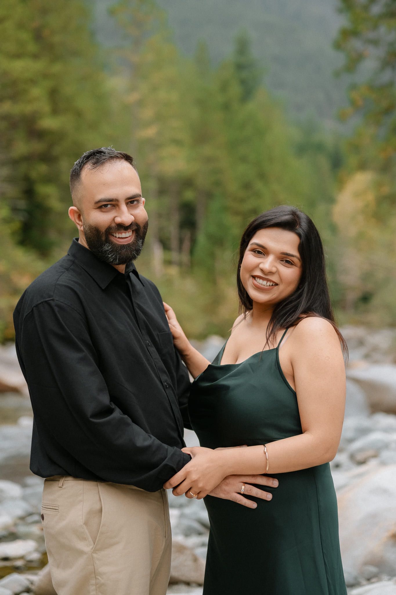Creative engagement photos, couple embracing on a river beach surrounded by forest