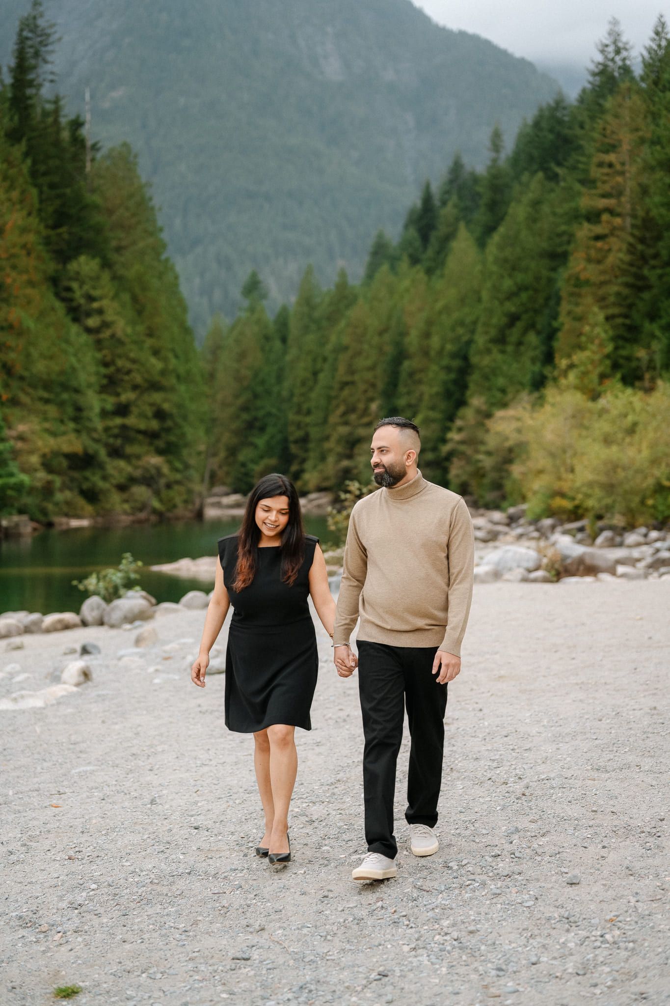 Professional couple photos, couple embracing on a river beach surrounded by forest