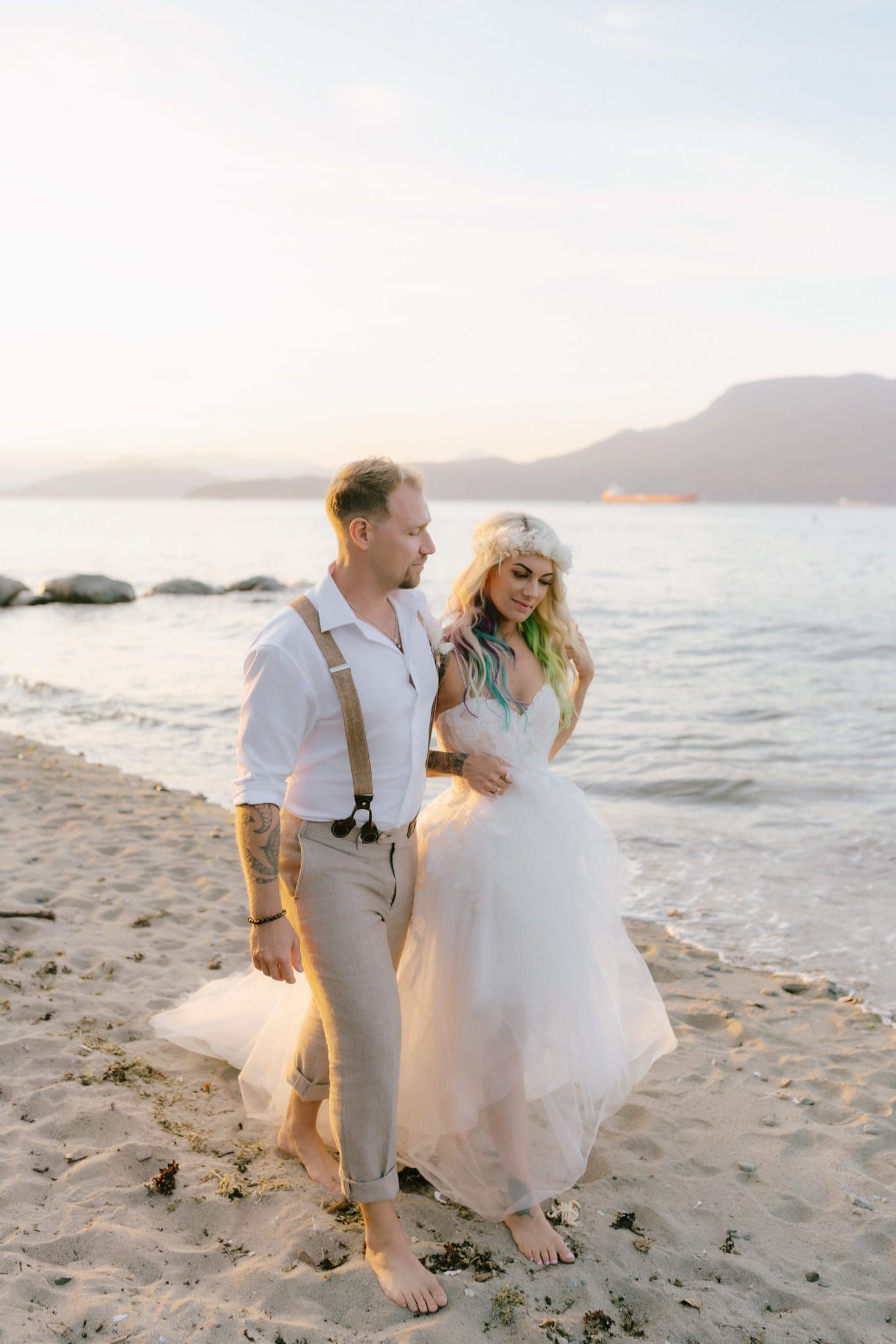 Golden hour wedding photos at sunset, bride and groom laughing on a sandy beach
