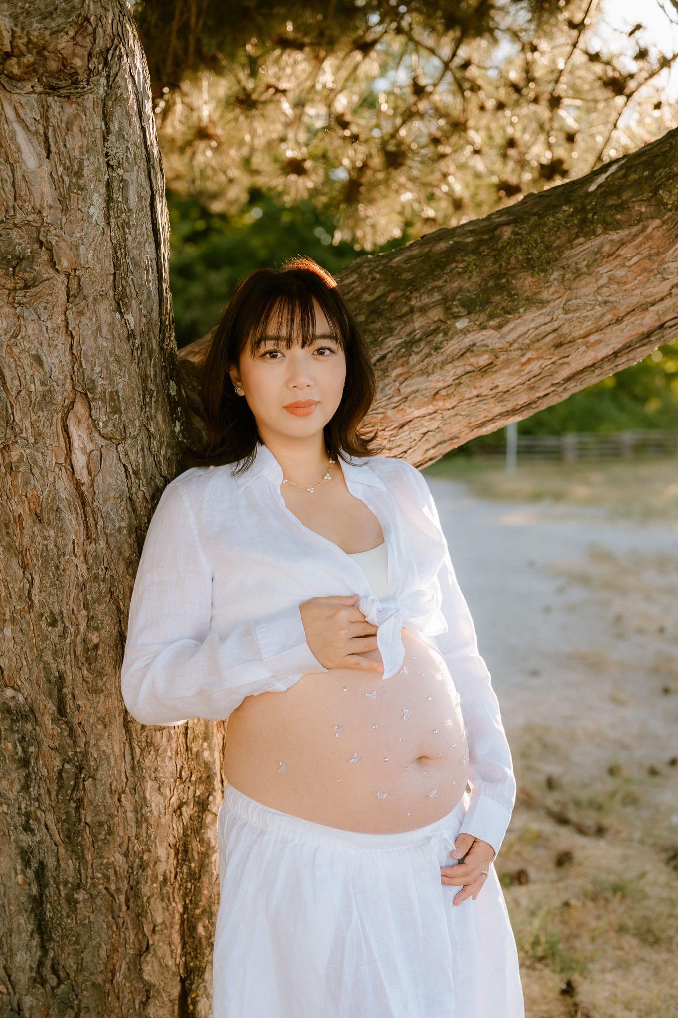 Sunset maternity photos on the beach, expectant mother in white