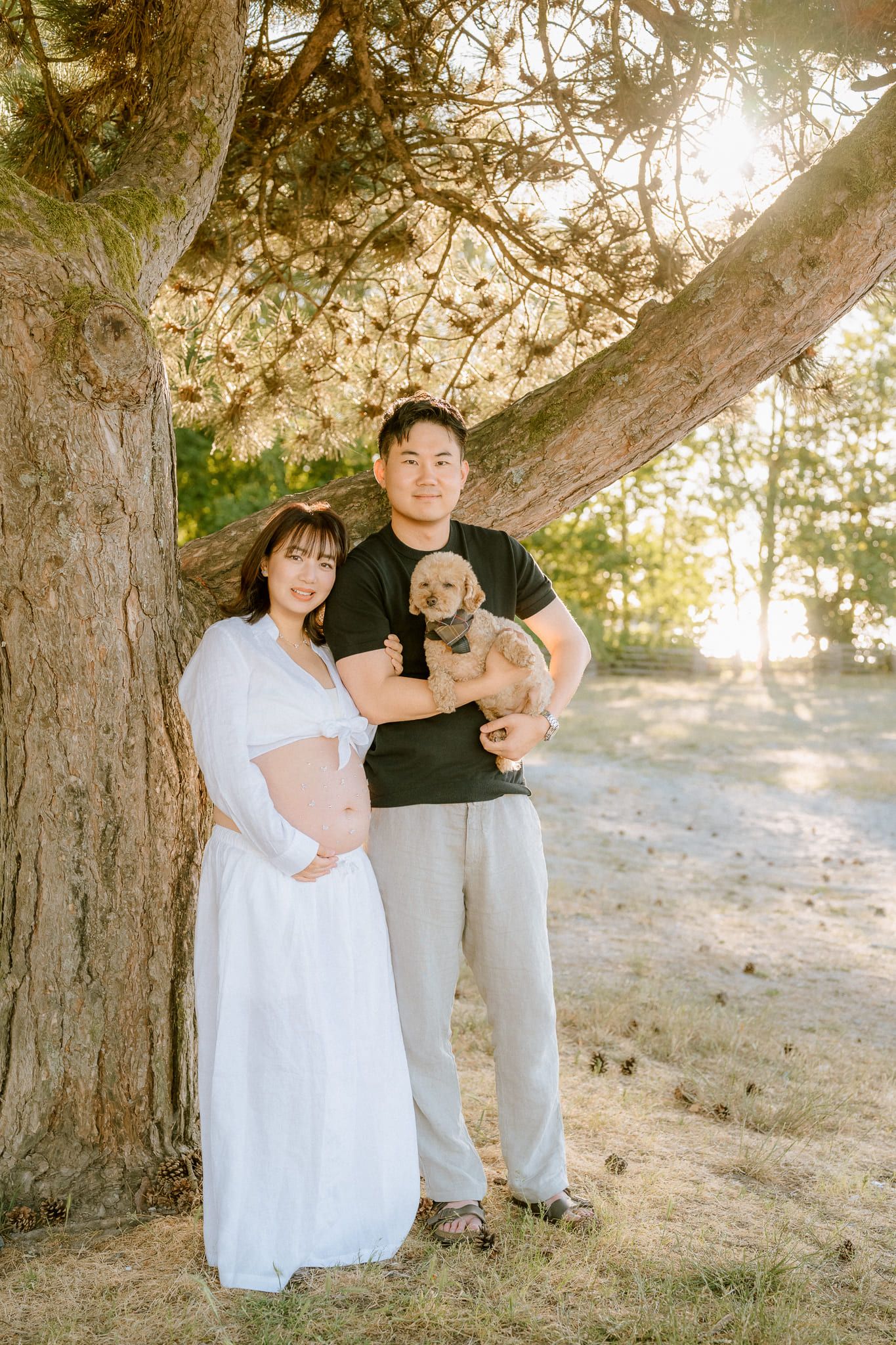 Maternity beach photography at sunset, expectant mother in white