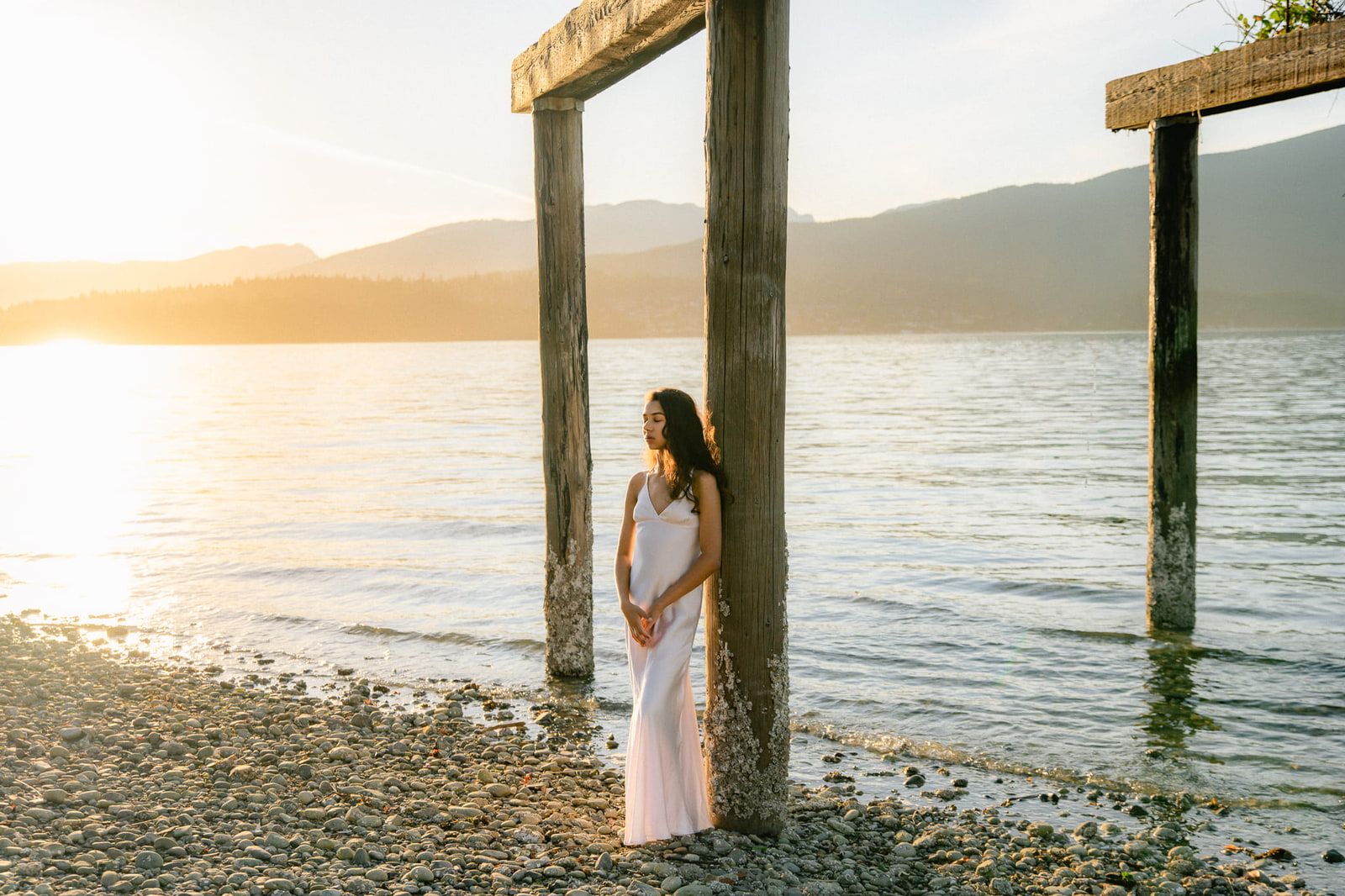 Sunset portrait photography on the beach, young woman in a white gown