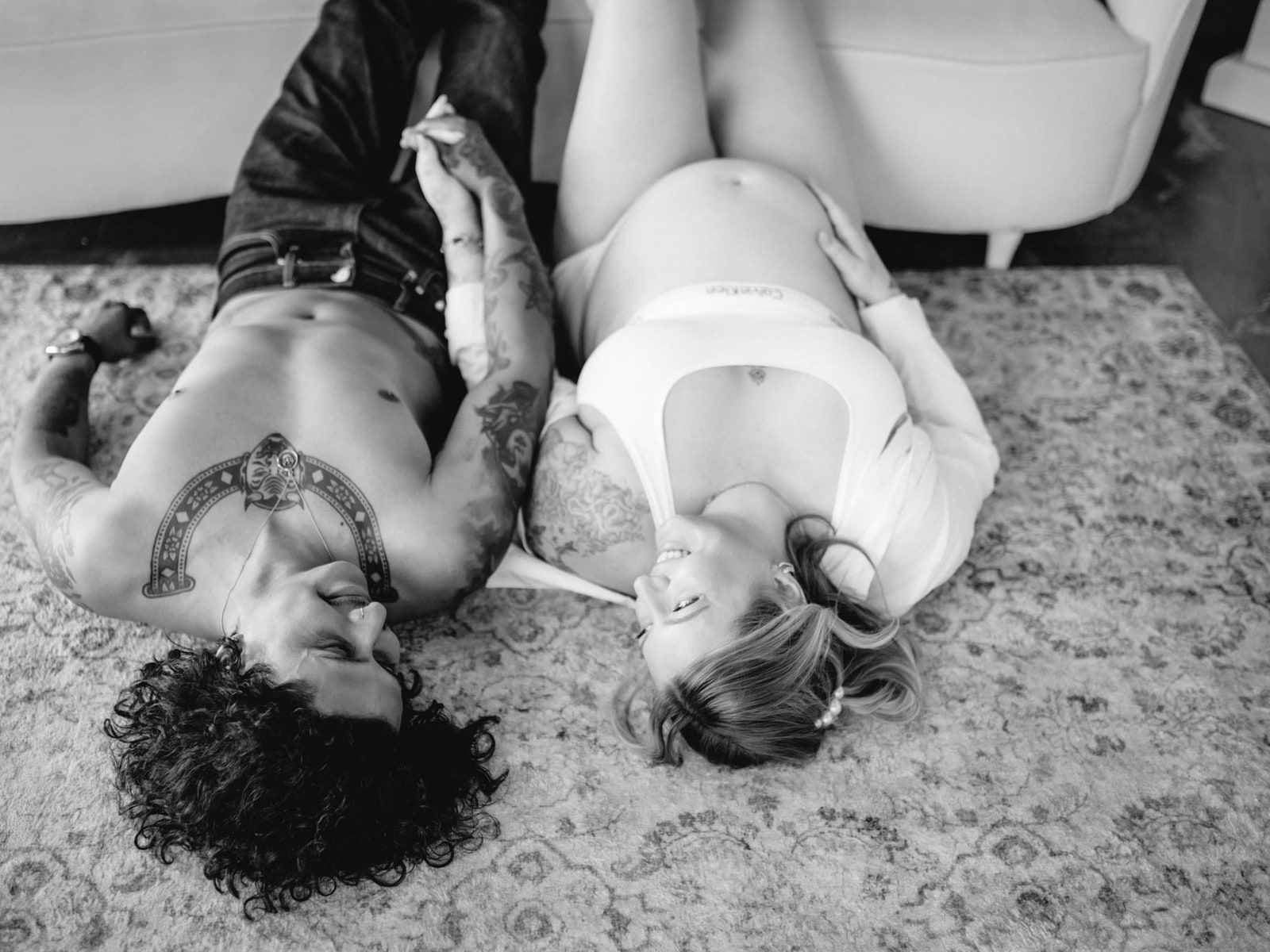 Moody engagement photos, black-and-white photo of a couple lying head to head on a rug
