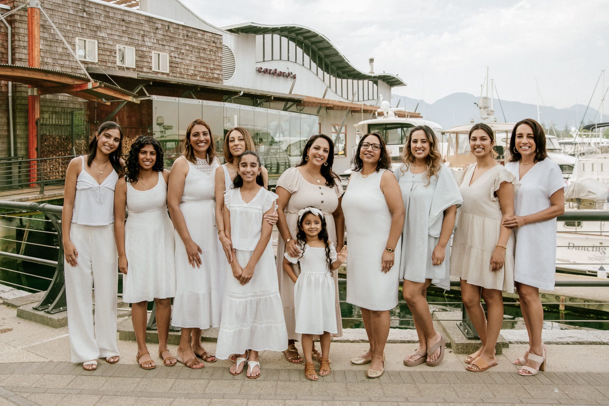 Classic family photos at a marina, large family dressed in white standing together