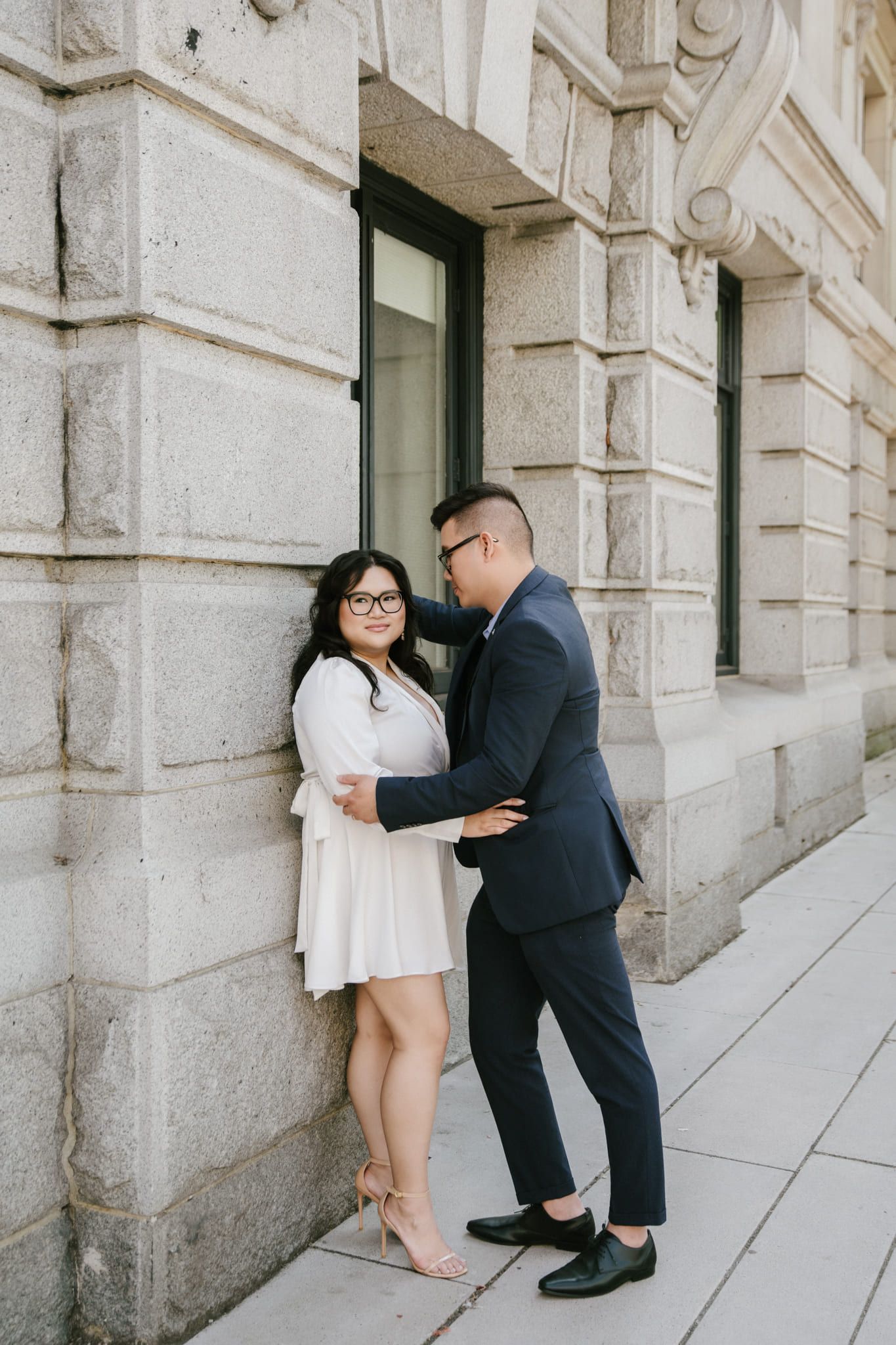 Downtown engagement photos, couple in formal wear on the steps of a stone building downtown