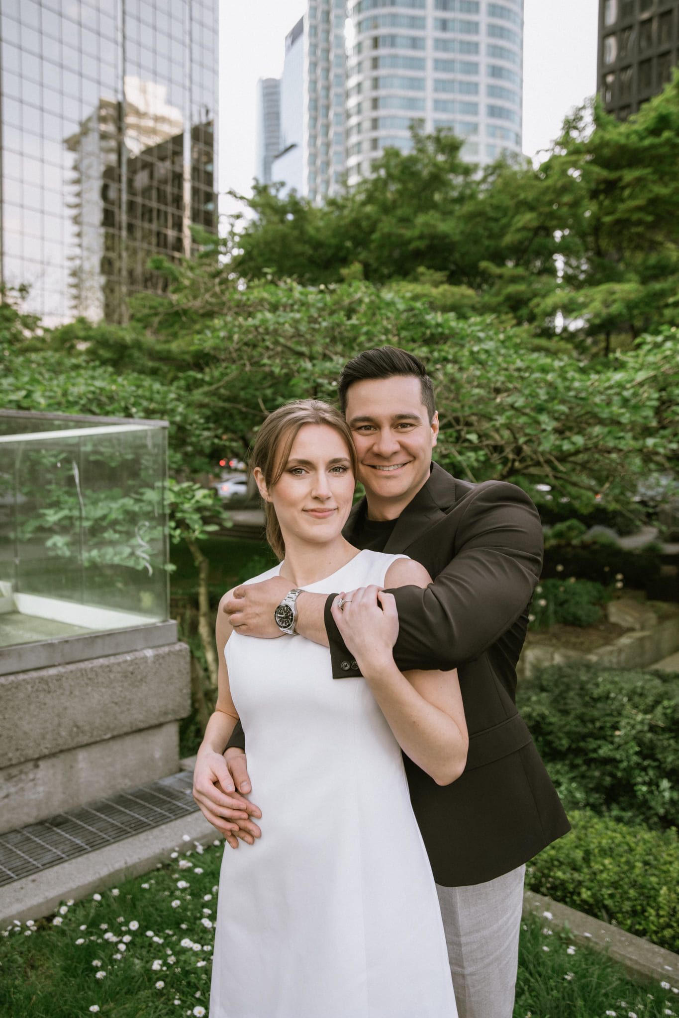 Urban engagement photos among downtown towers, couple in white and black