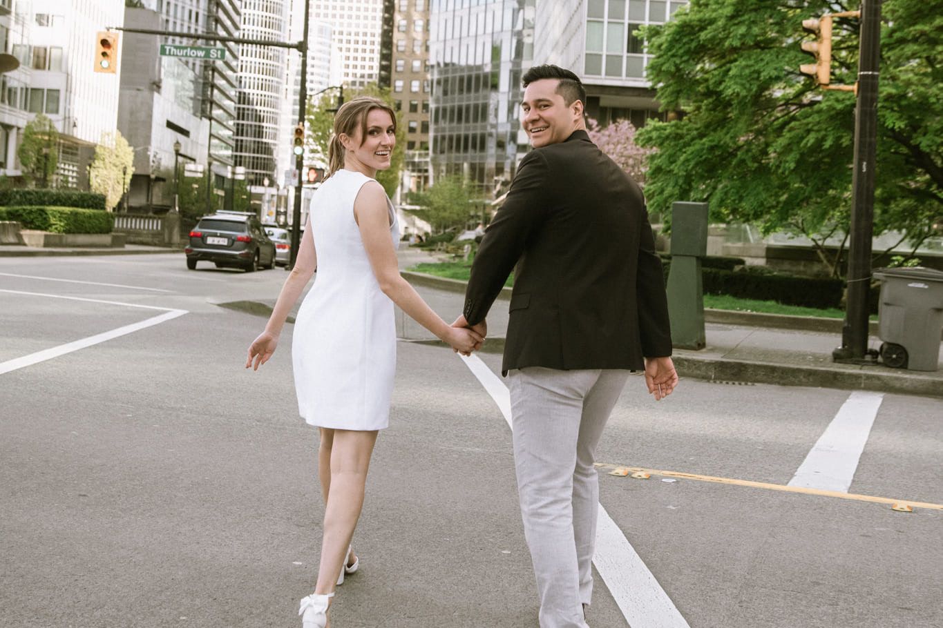 Engagement shoot across a downtown street, couple walking hand in hand