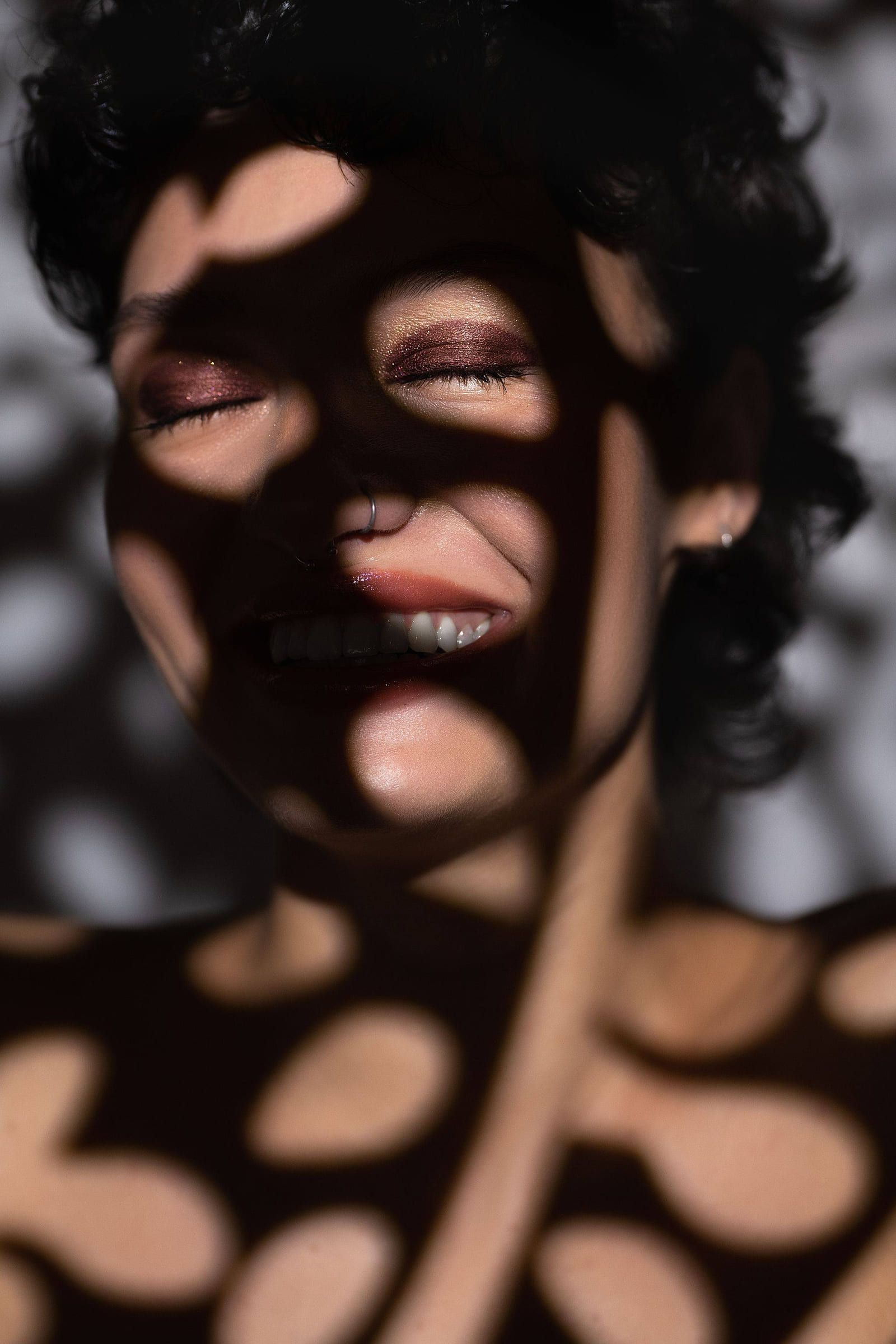 Model's face patterned with dappled shadow