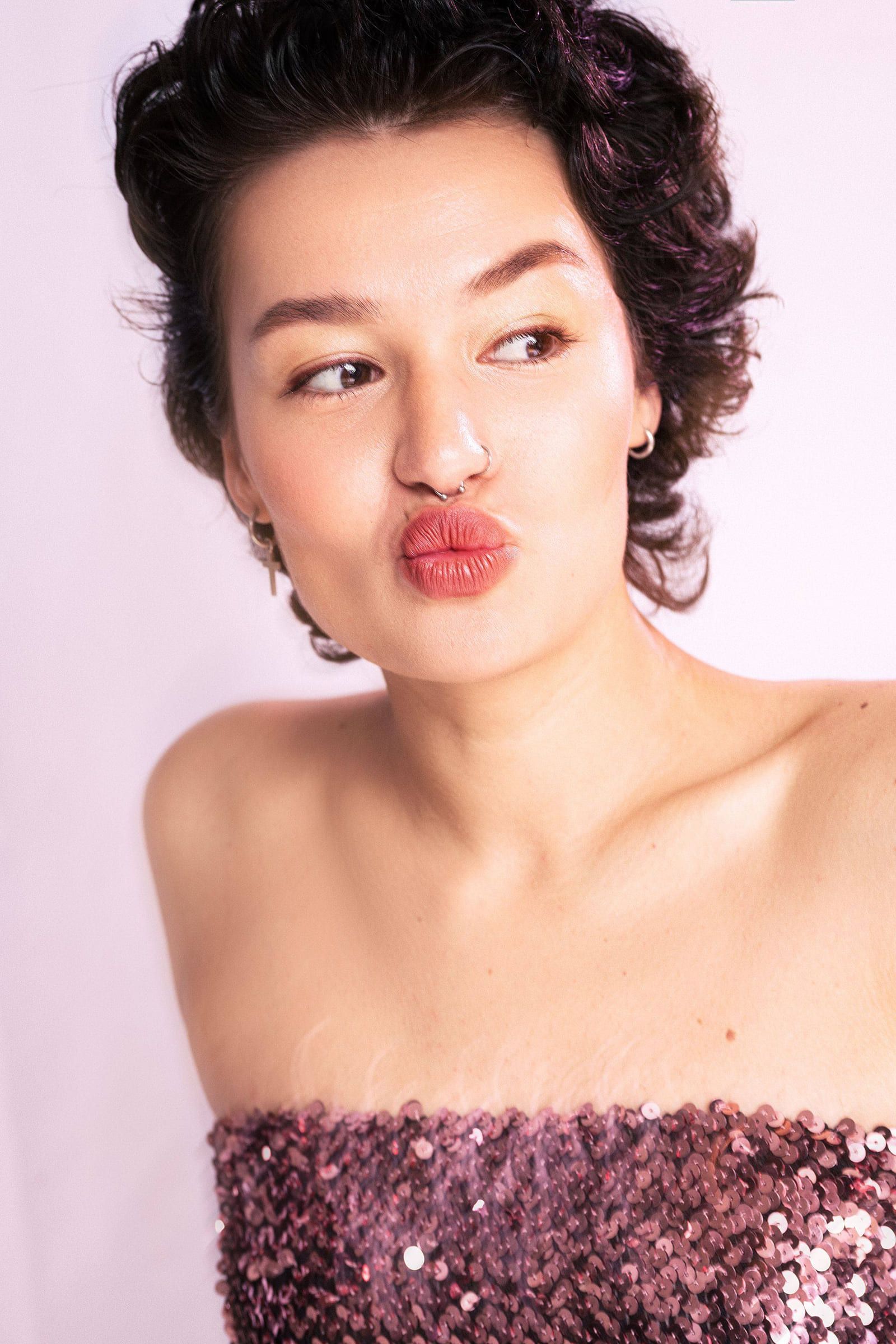 Model in a sequined tube dress pouting at the camera