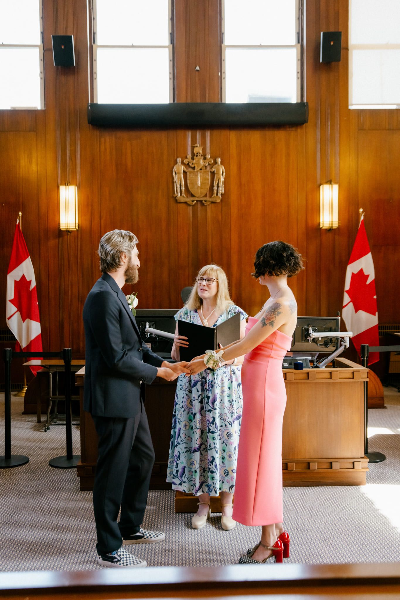 Classic wedding photos, couple exchanging vows before an officiant in a wood-panelled room