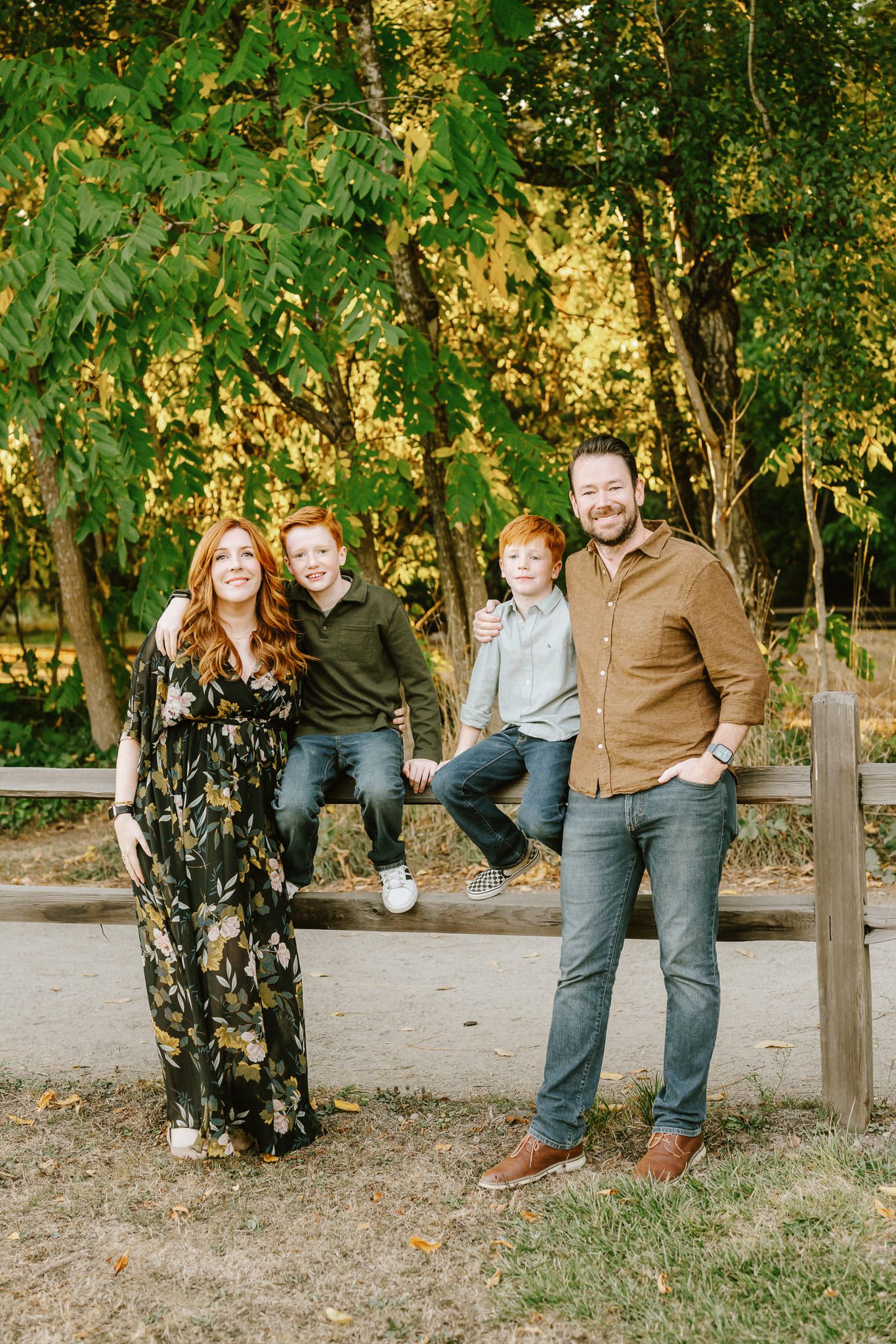 Family photos, family of four by a wooden fence in warm evening light