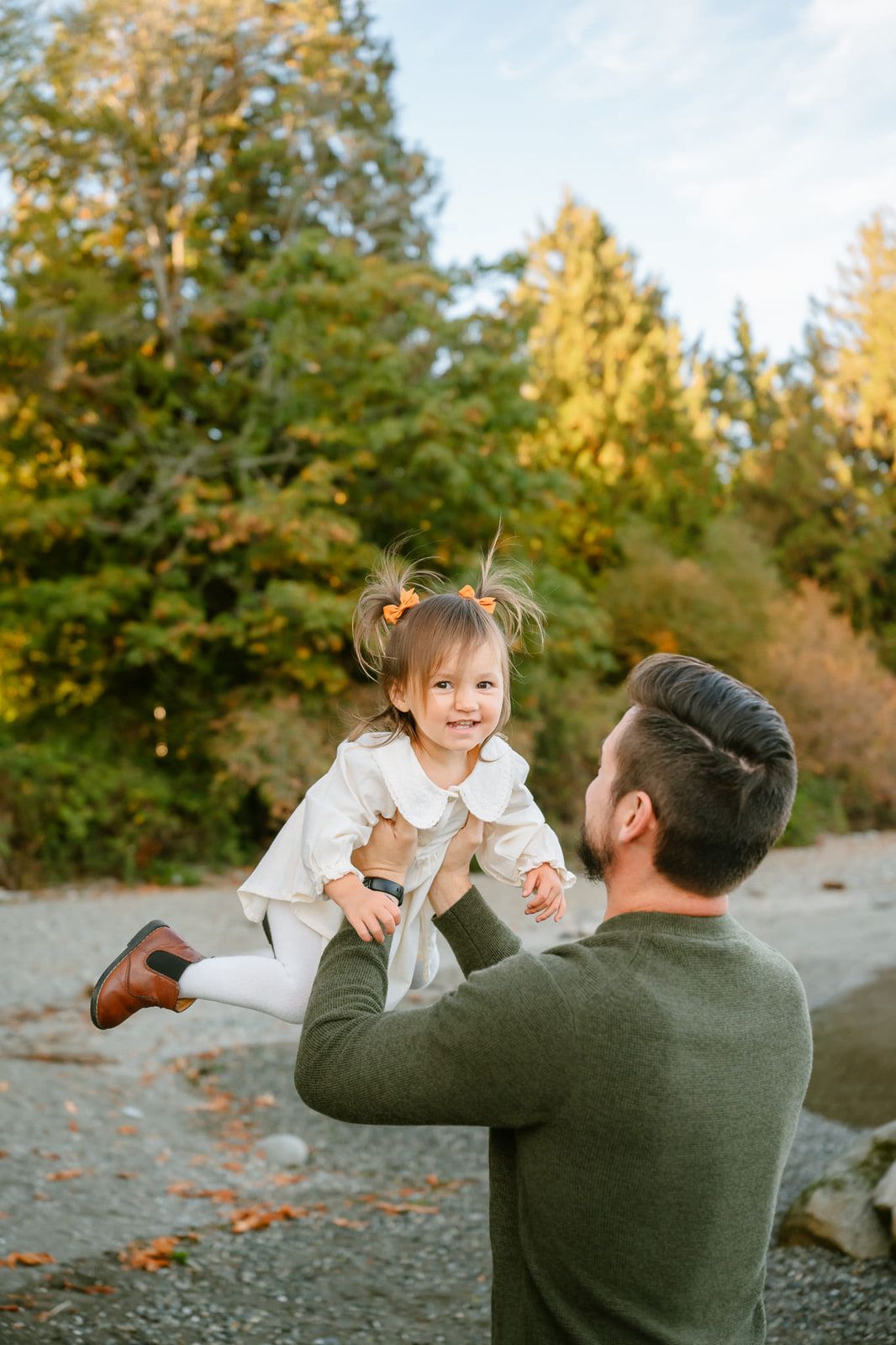 Portrait and family photography, father lifting his toddler daughter high in the air