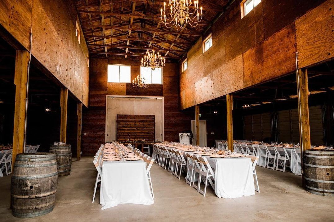 Outdoor wedding shoot, barn interior with long tables set for a wedding dinner