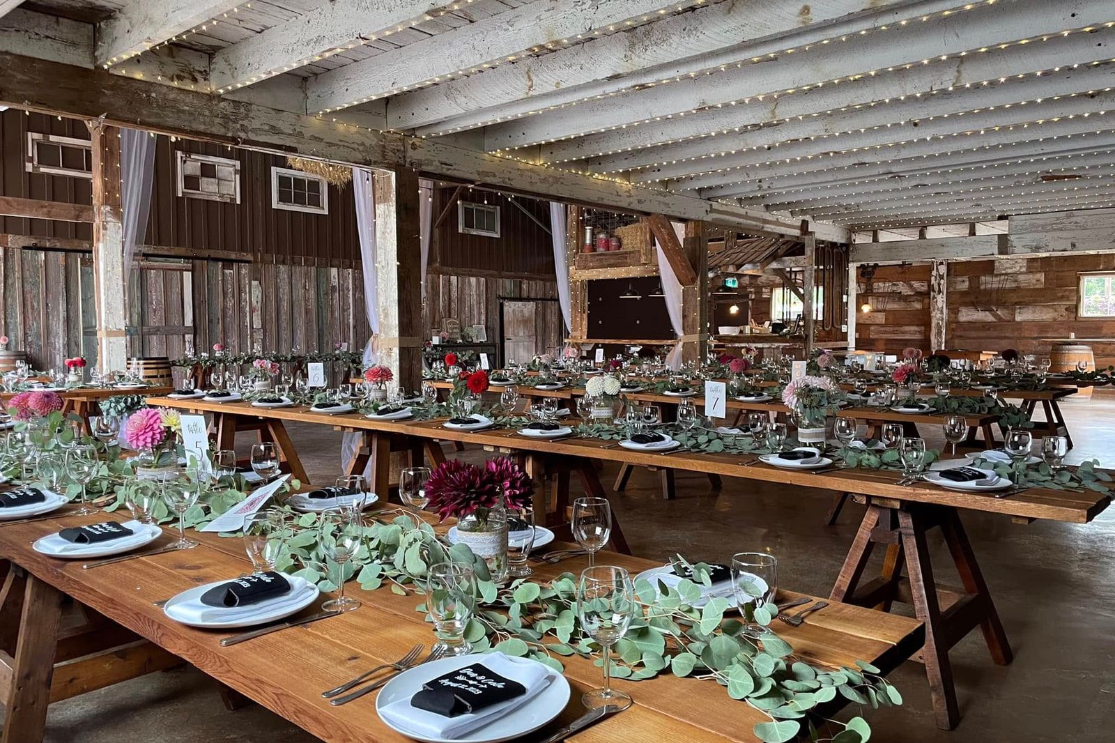 Elopement pictures, long wooden tables with greenery in the barn at The White Owl