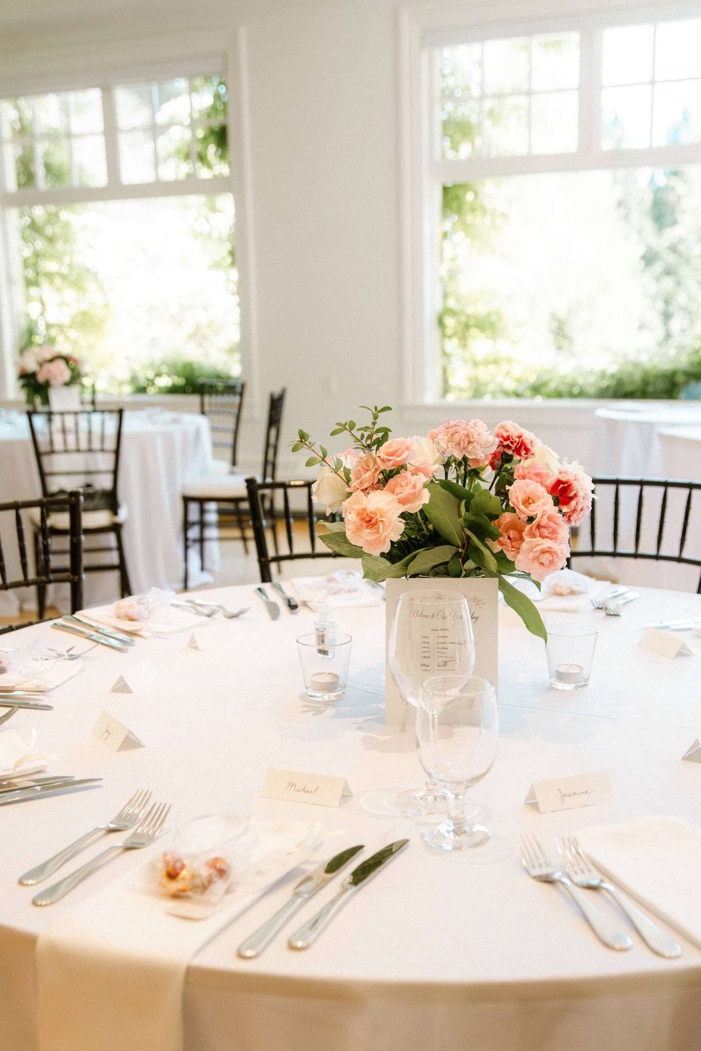 Reception table with a peach and pink floral centrepiece