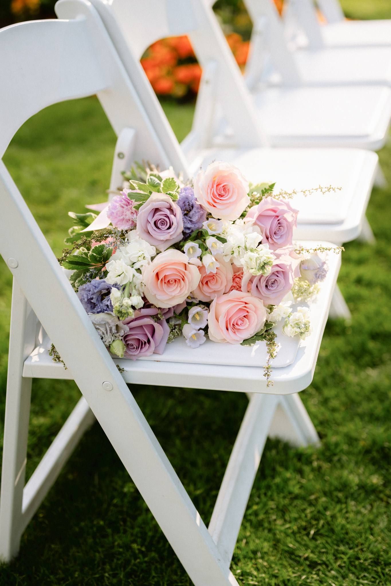 Pastel bouquet resting on a white folding chair