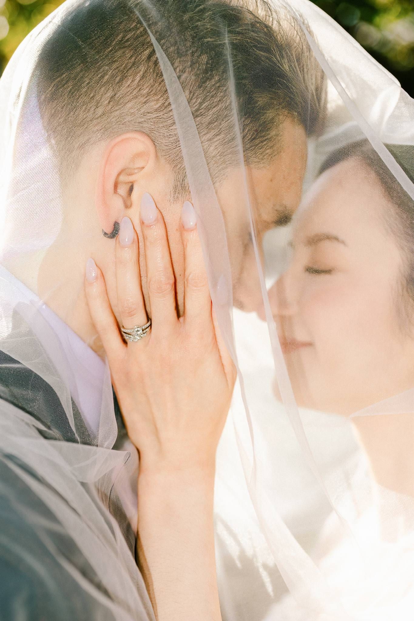 Close-up of the couple nose to nose beneath the veil