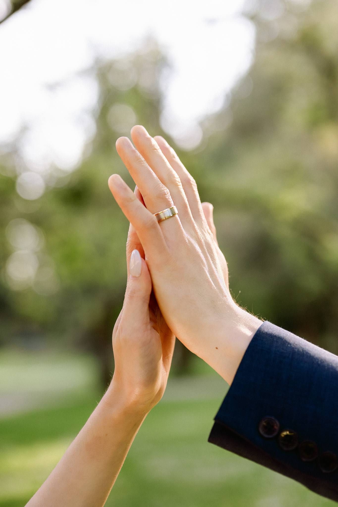 Couple's hands pressed together, her ring in view