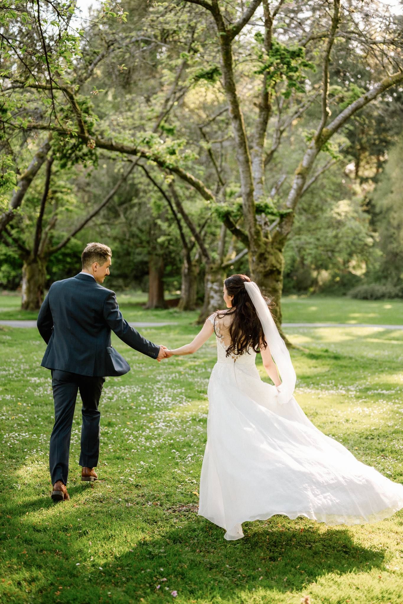 Couple walking hand in hand across the garden lawn