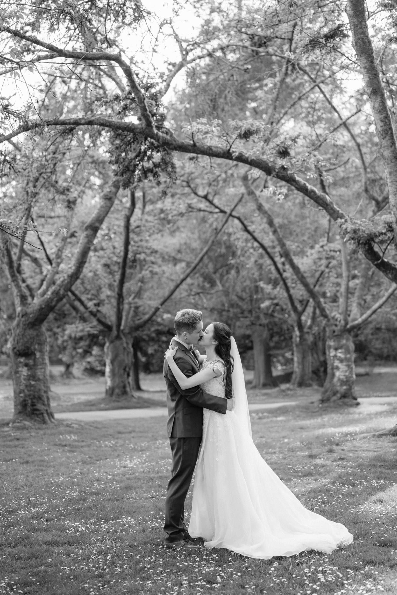 Black-and-white photo of the couple beneath the garden trees
