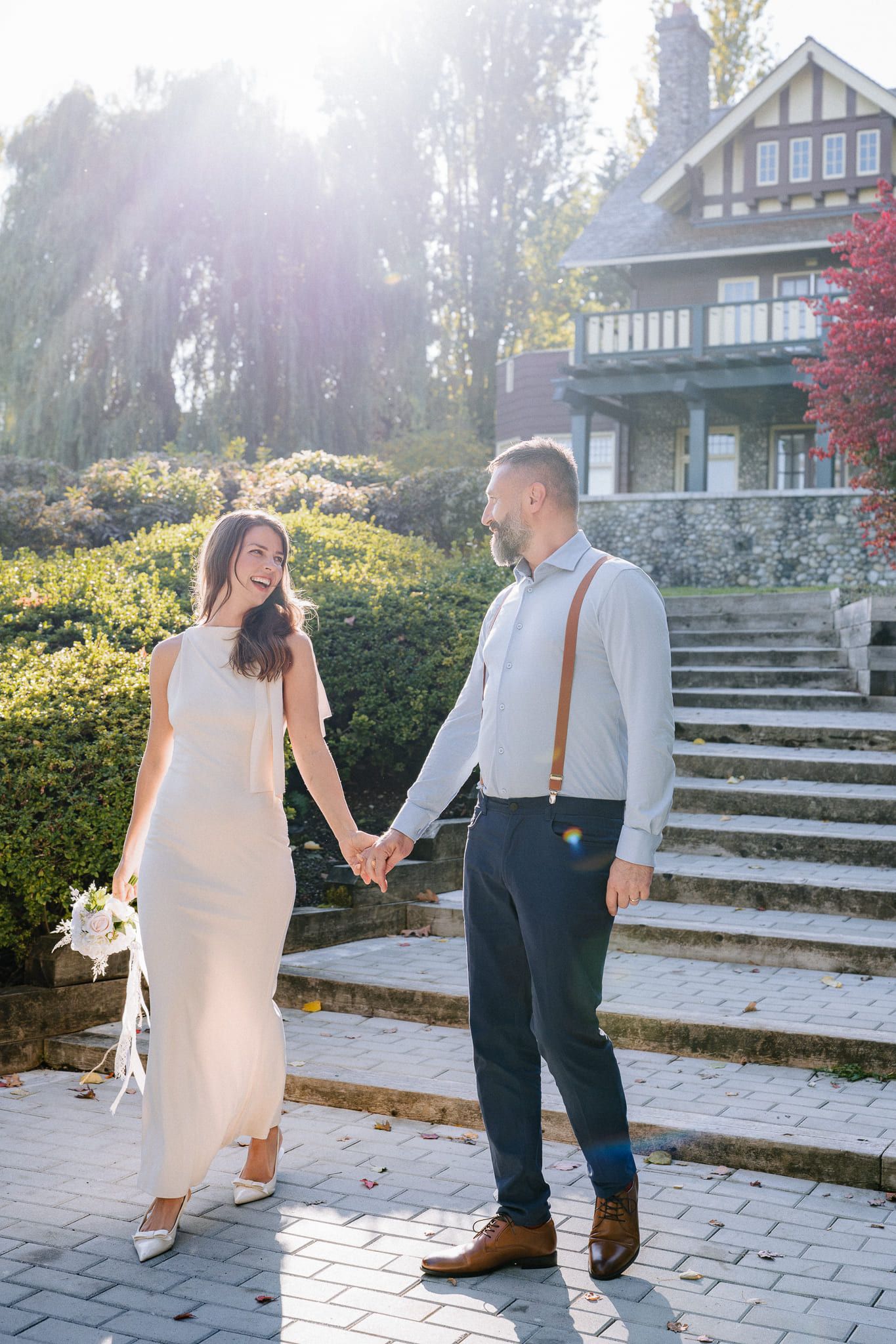 Creative wedding photos, bride and groom holding hands at the foot of stone garden steps