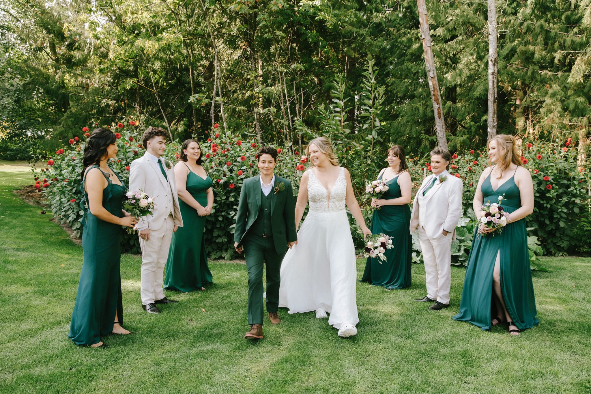 Outdoor bridal photoshoot, wedding party in green walking across a garden lawn