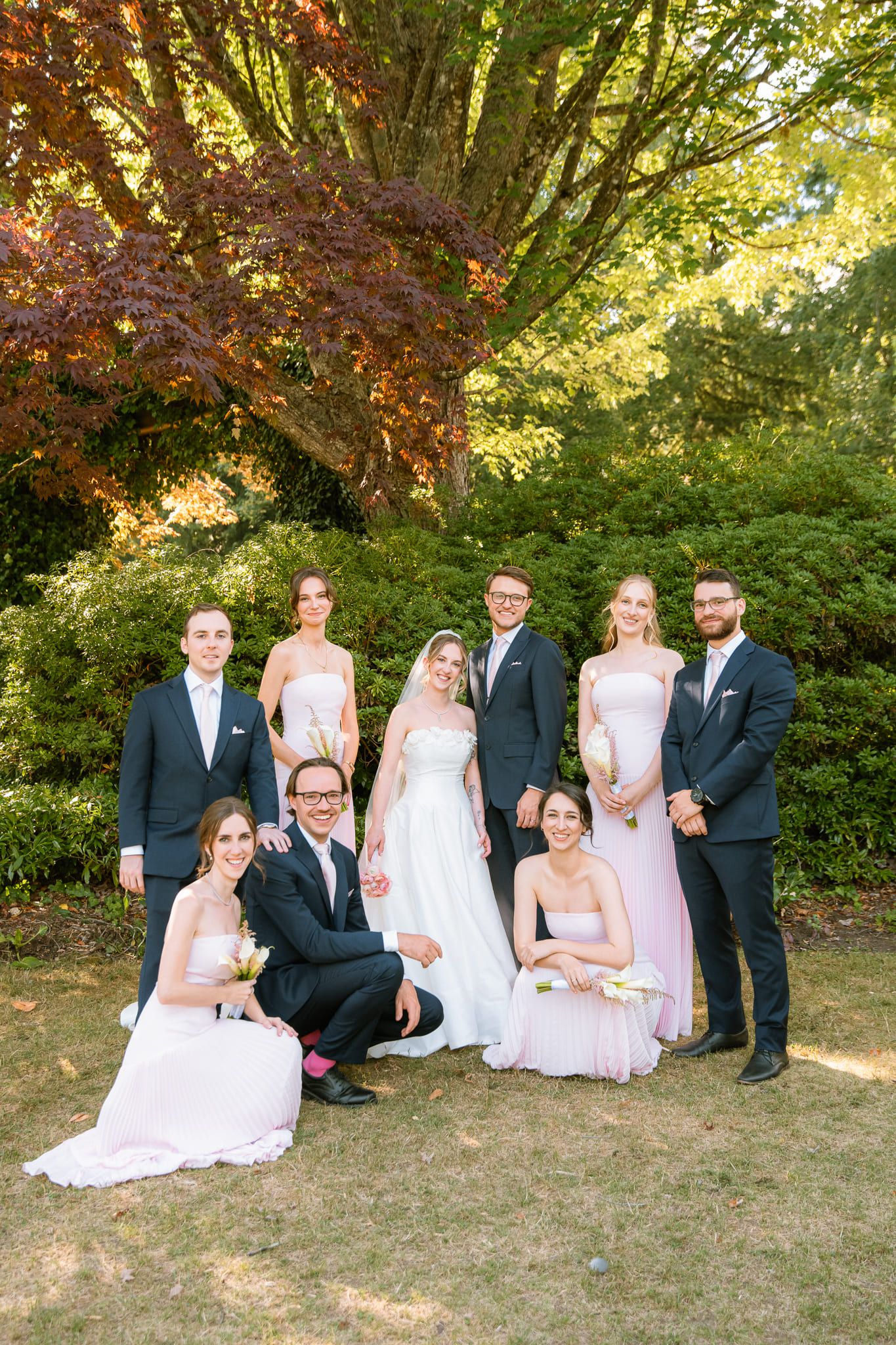 Professional wedding pictures, wedding party posing in a garden in late-day sun