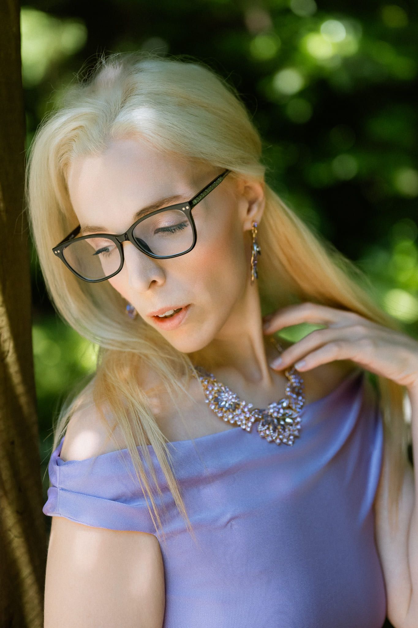 Branding photo in a greenhouse garden, woman in a lilac dress and glasses