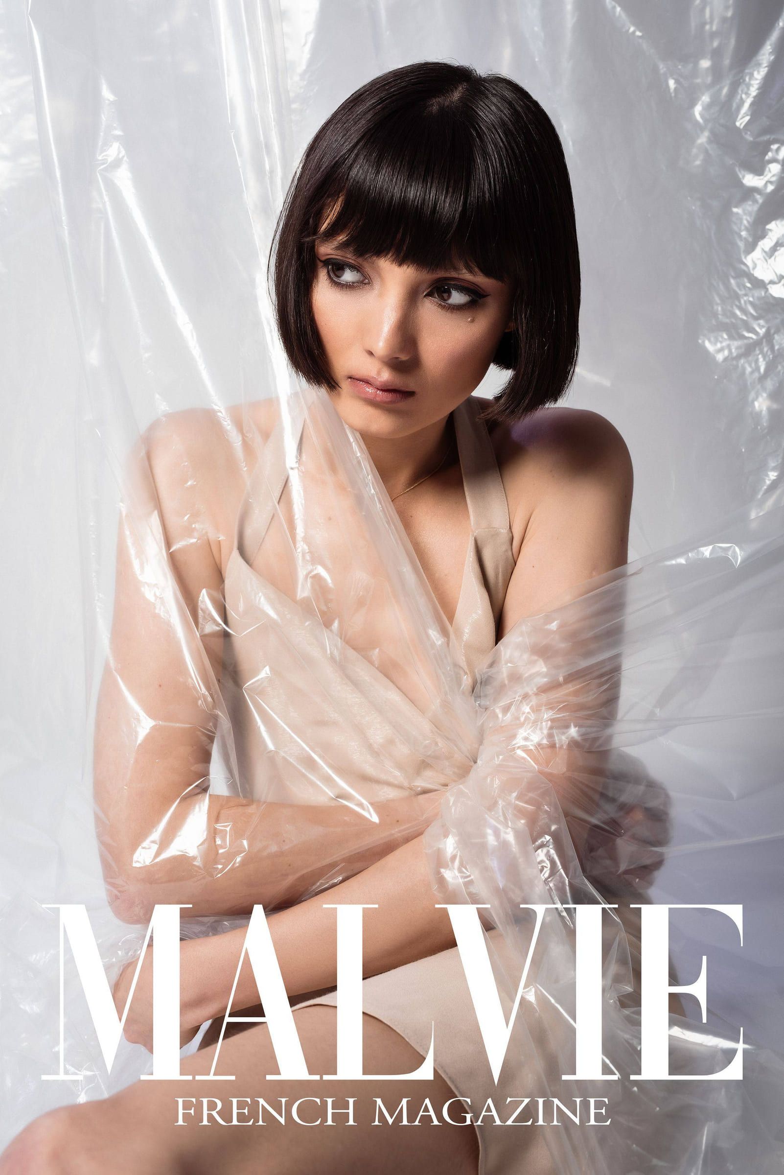 Model with a dark bob in a cream draped top on the cover of Malvie magazine