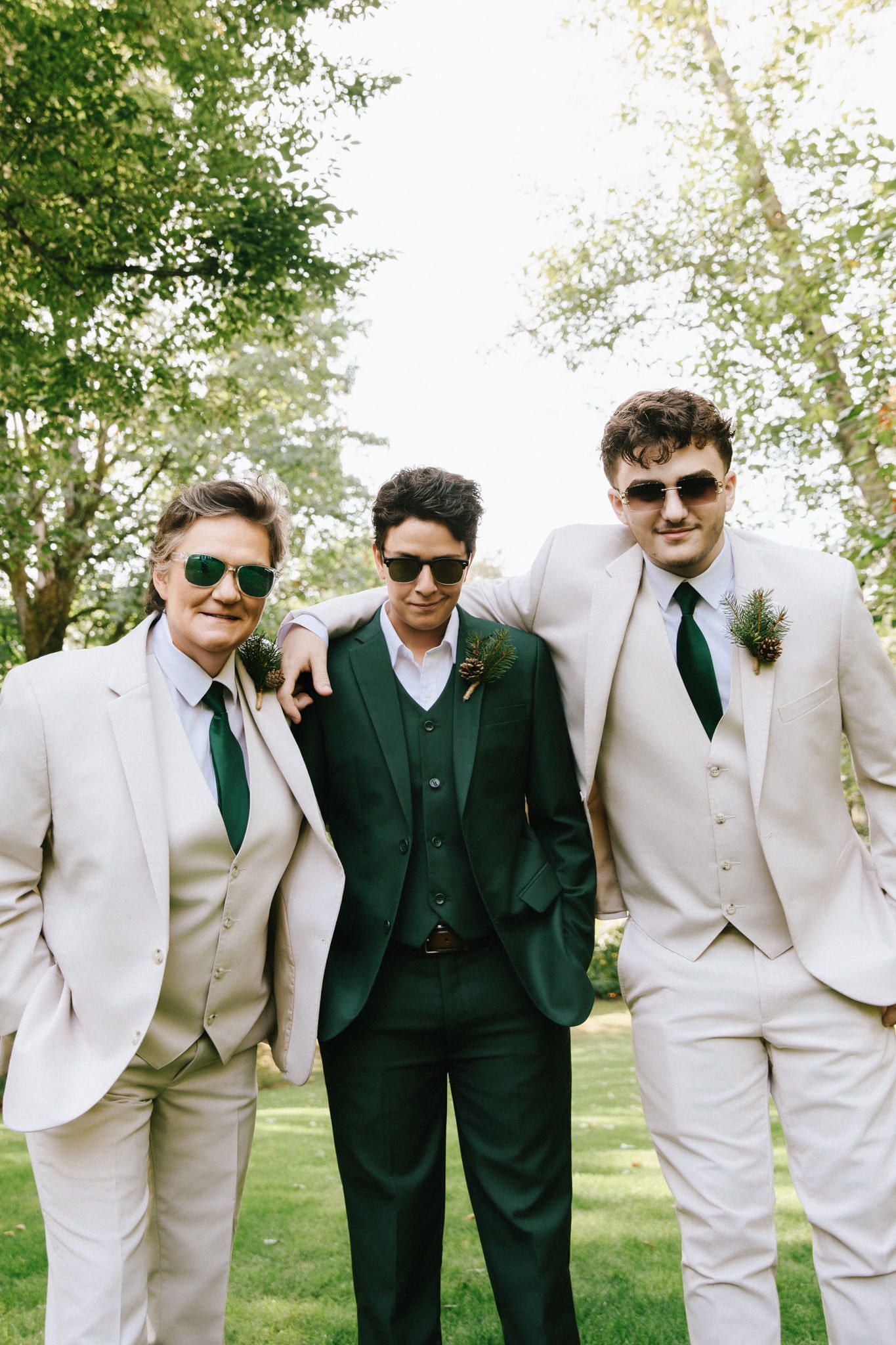 Creative wedding photography on the lawn, groom and two groomsmen in sunglasses