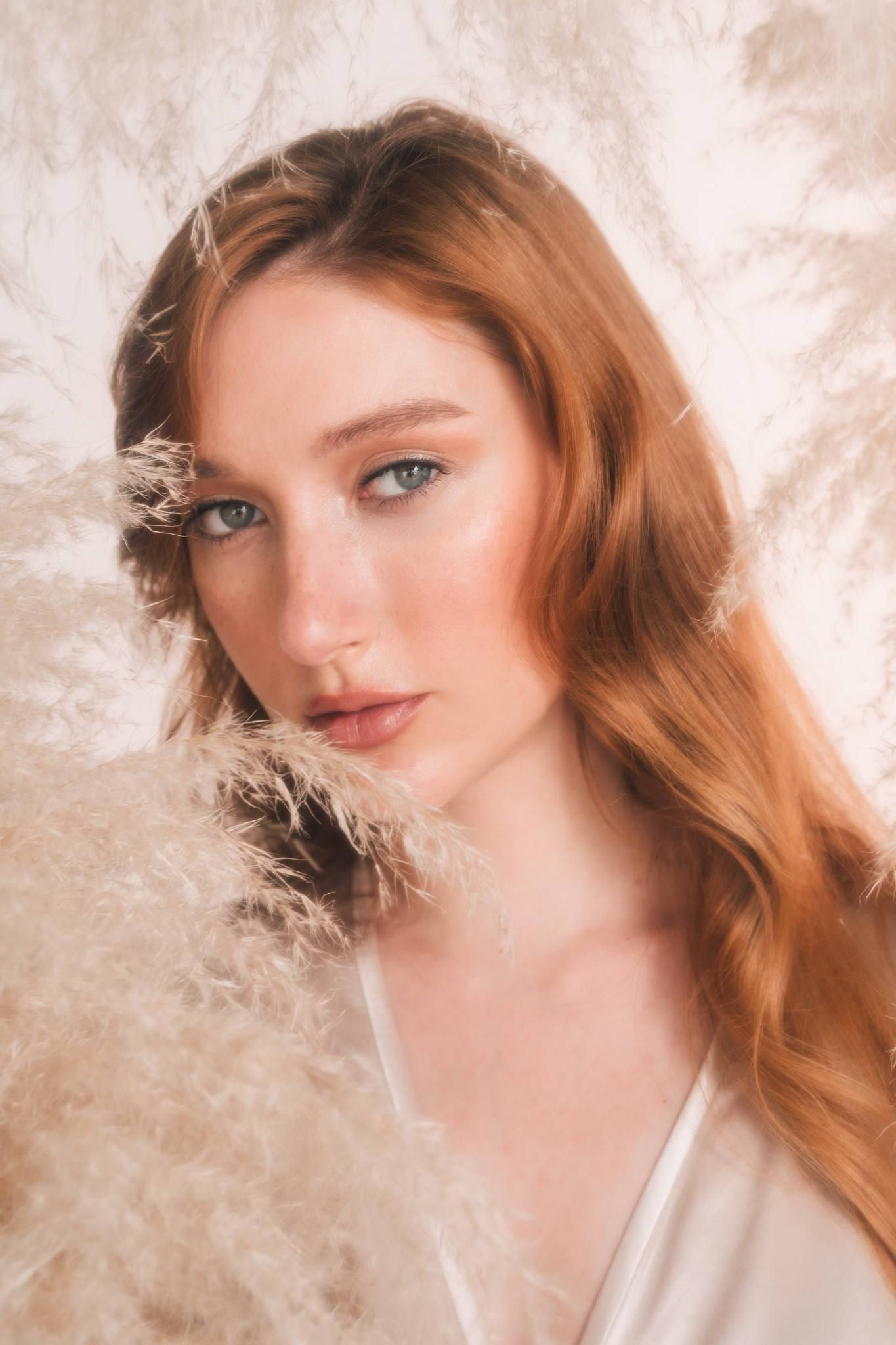 Beauty close-up of a red-haired model among pampas grass