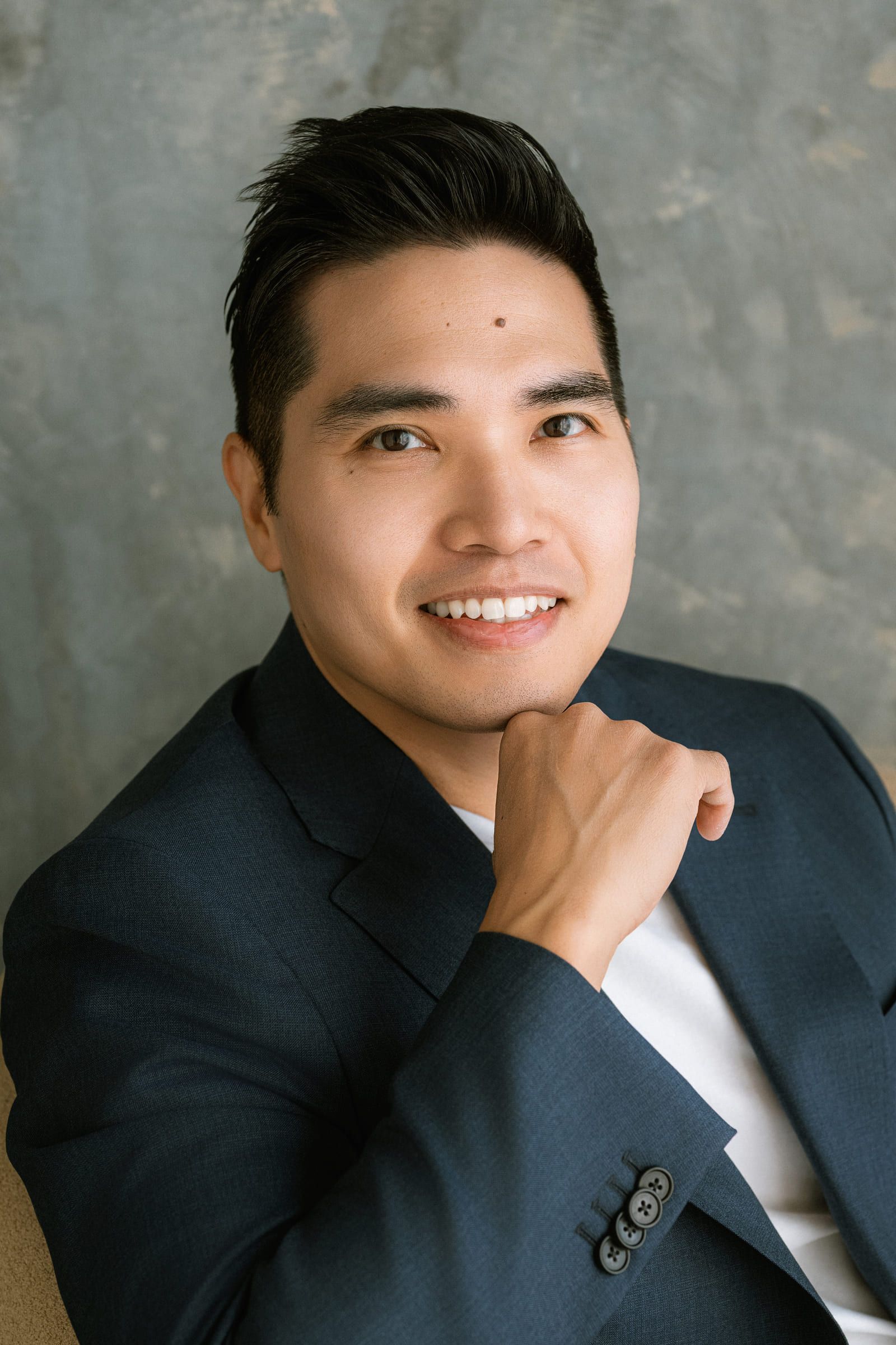 Corporate photography, professional headshot of a smiling man in a blazer