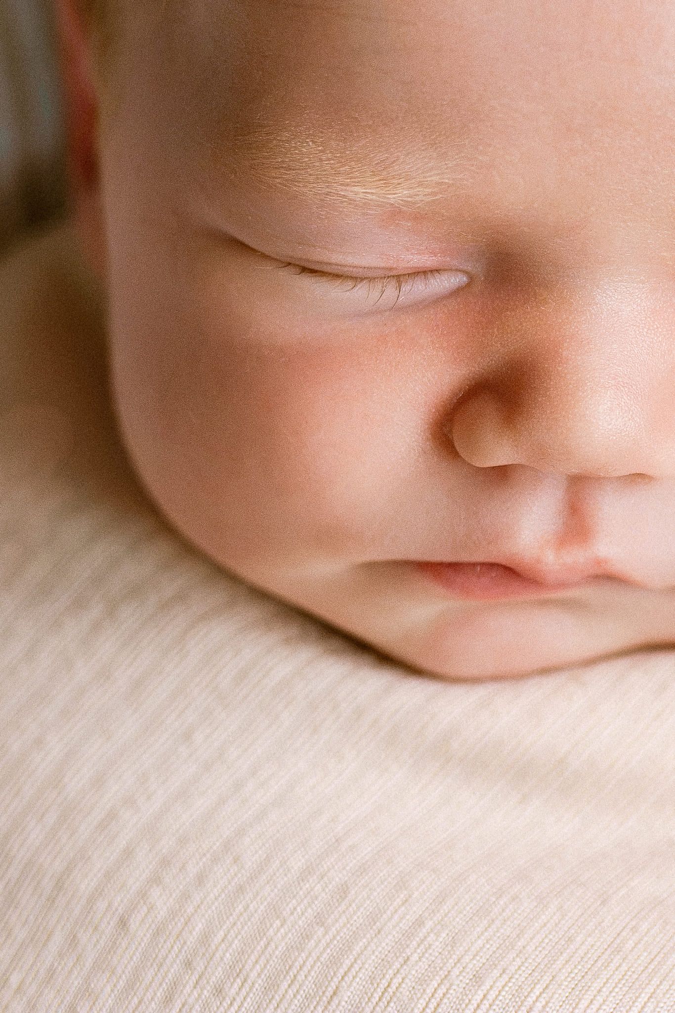 Newborn photoshoot at home, newborn baby girl in cream, cuddled by her parents