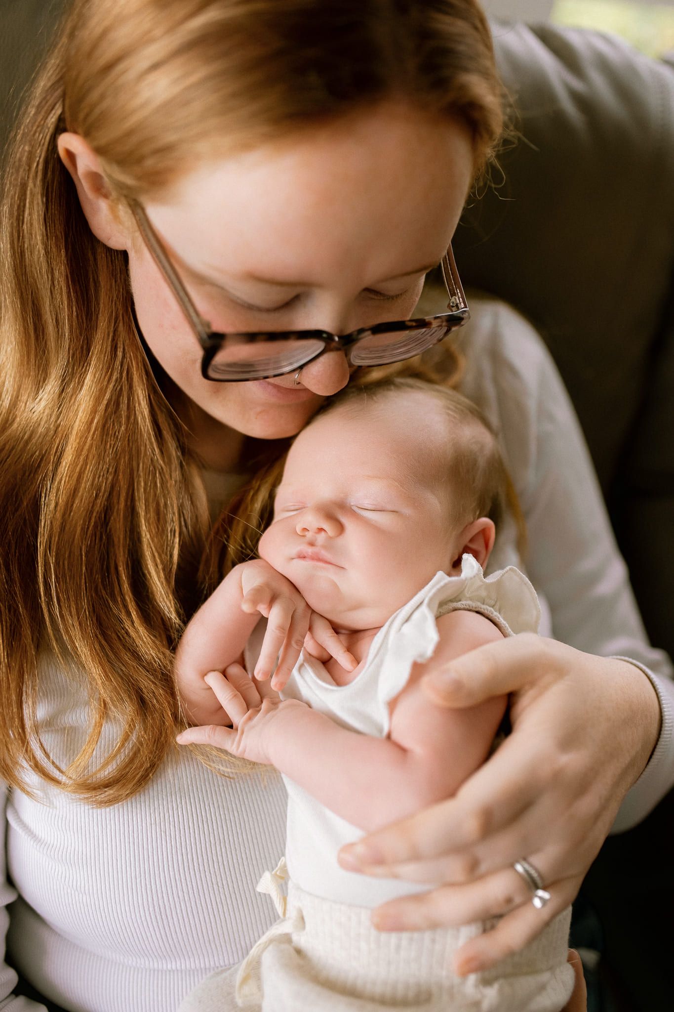 Newborn home photoshoot, newborn baby girl in cream, cuddled by her parents