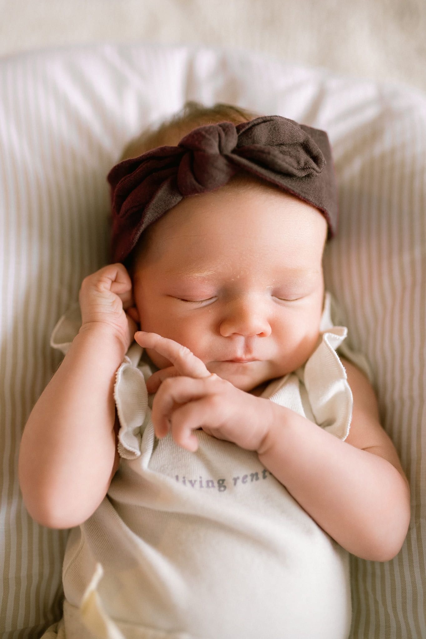 Newborn baby girl in cream, cuddled by her parents at home, by Langley newborn photographer Natalie Varro