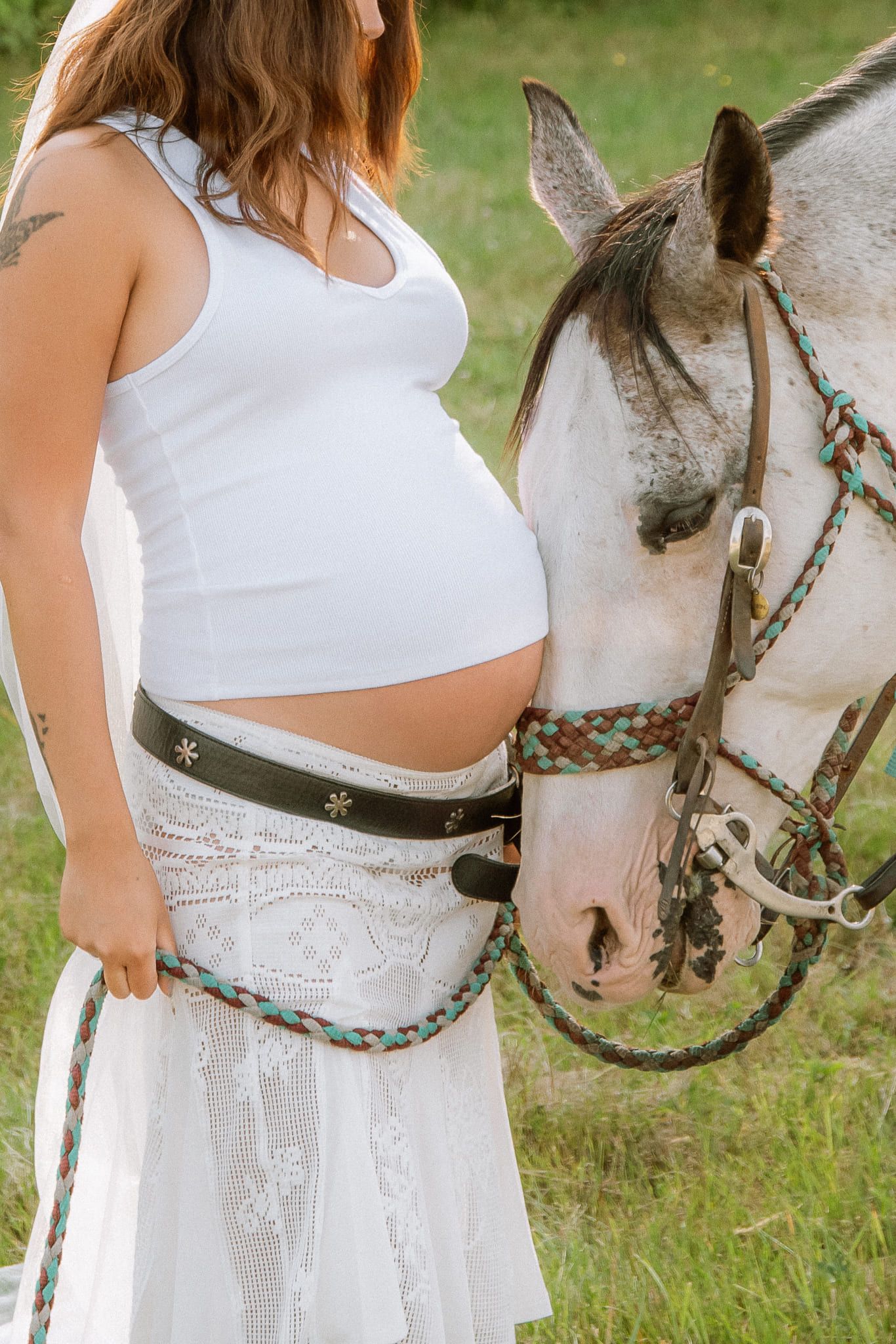 Maternity pictures, mom-to-be in white standing beside a white horse