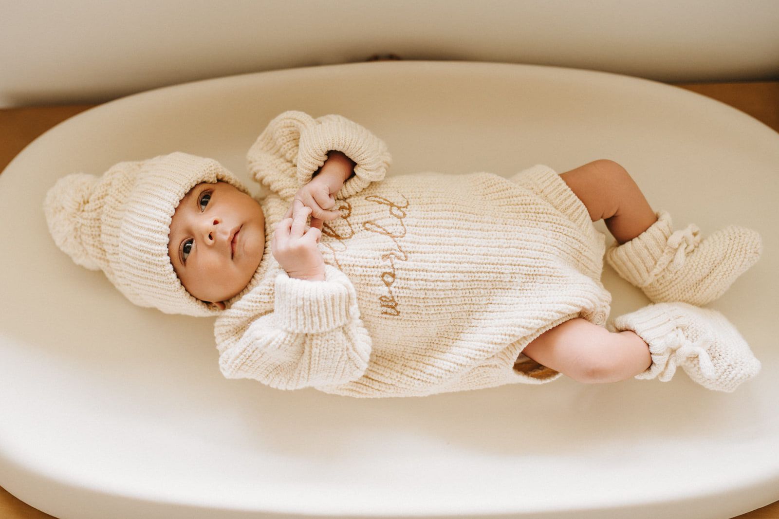 Newborn photos in Langley, newborn in a knit outfit and hat lying in a white basket