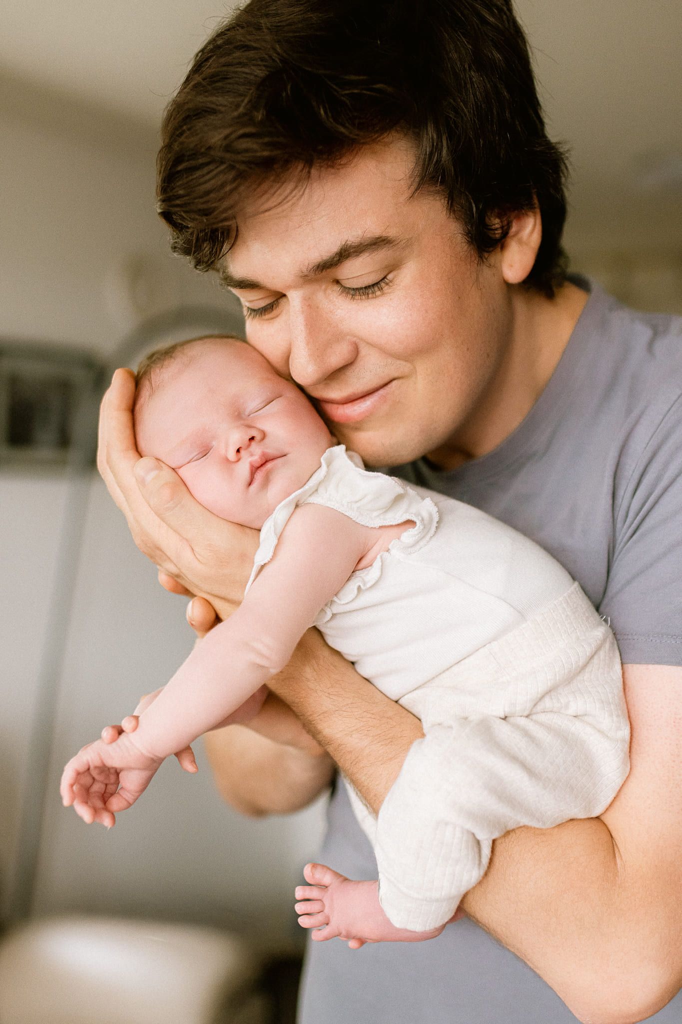 Newborn and dad photos, dad holding his sleeping newborn against his cheek