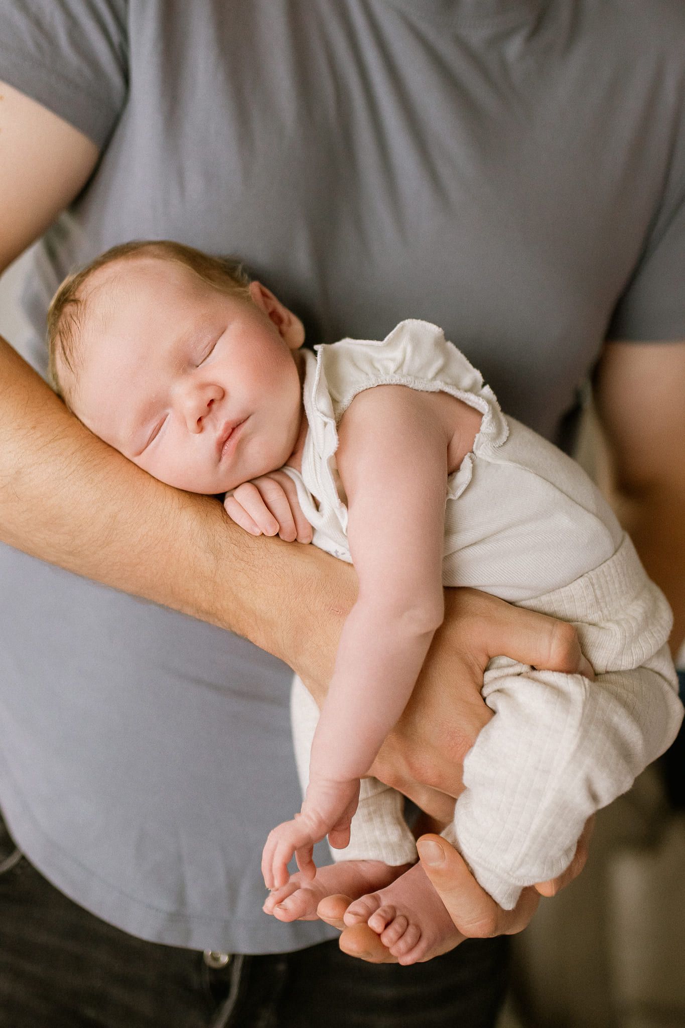 Creative dad newborn photography, newborn sleeping on her father's forearm