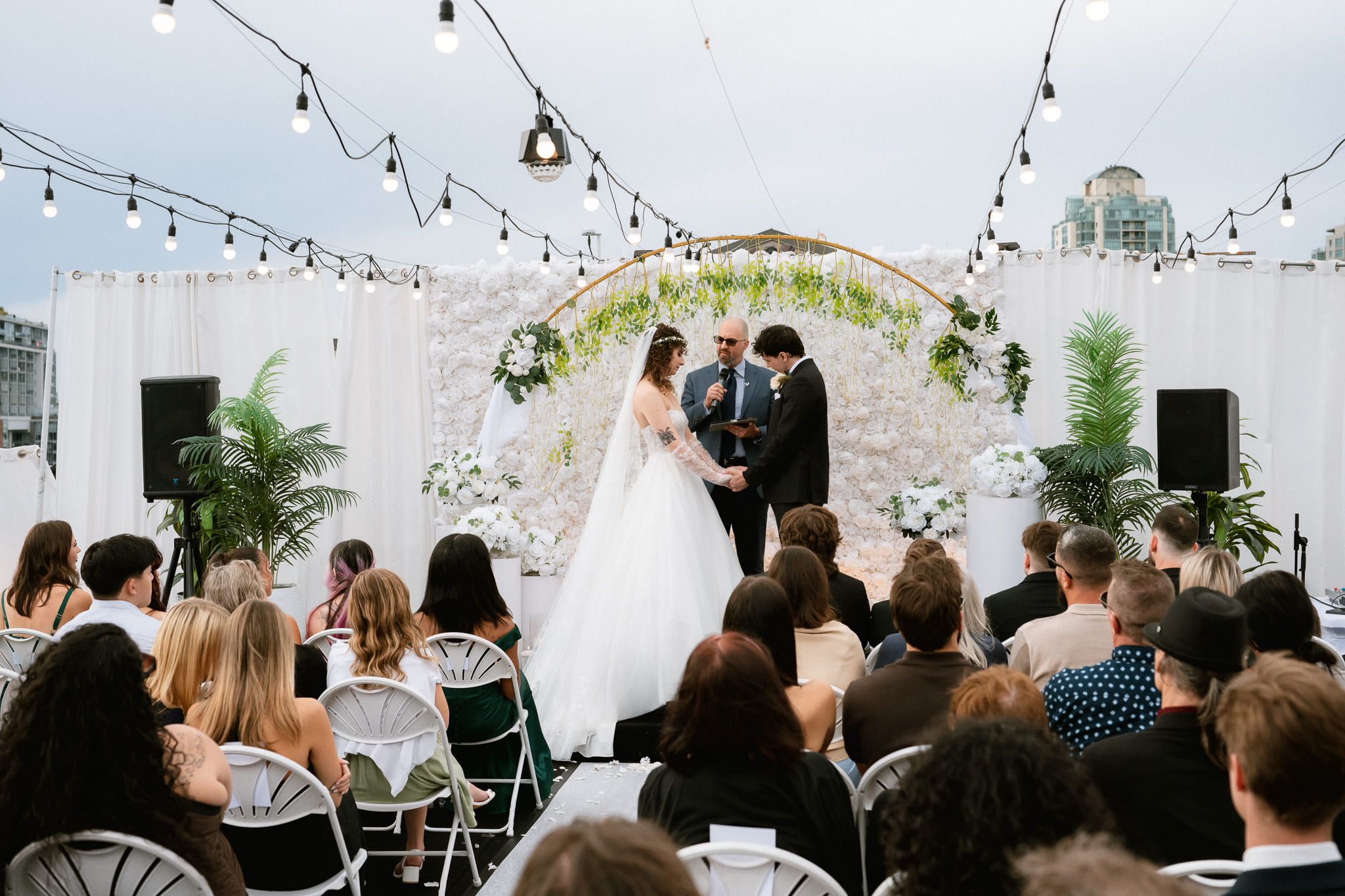 Outdoor wedding shoot, outdoor wedding ceremony under string lights and a floral arch