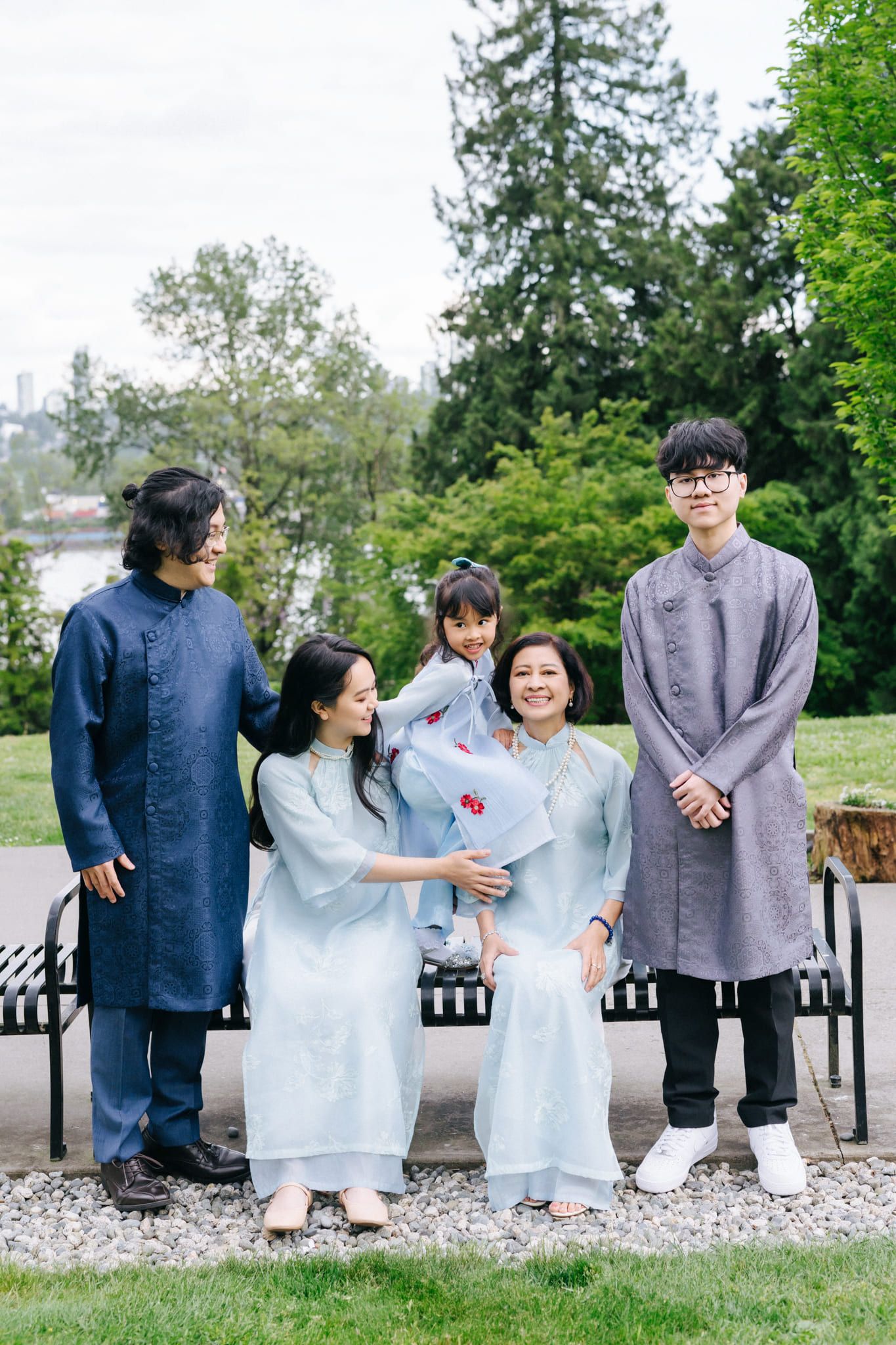 Family portrait sessions in a park, family in pale blue and navy traditional dress smiling together