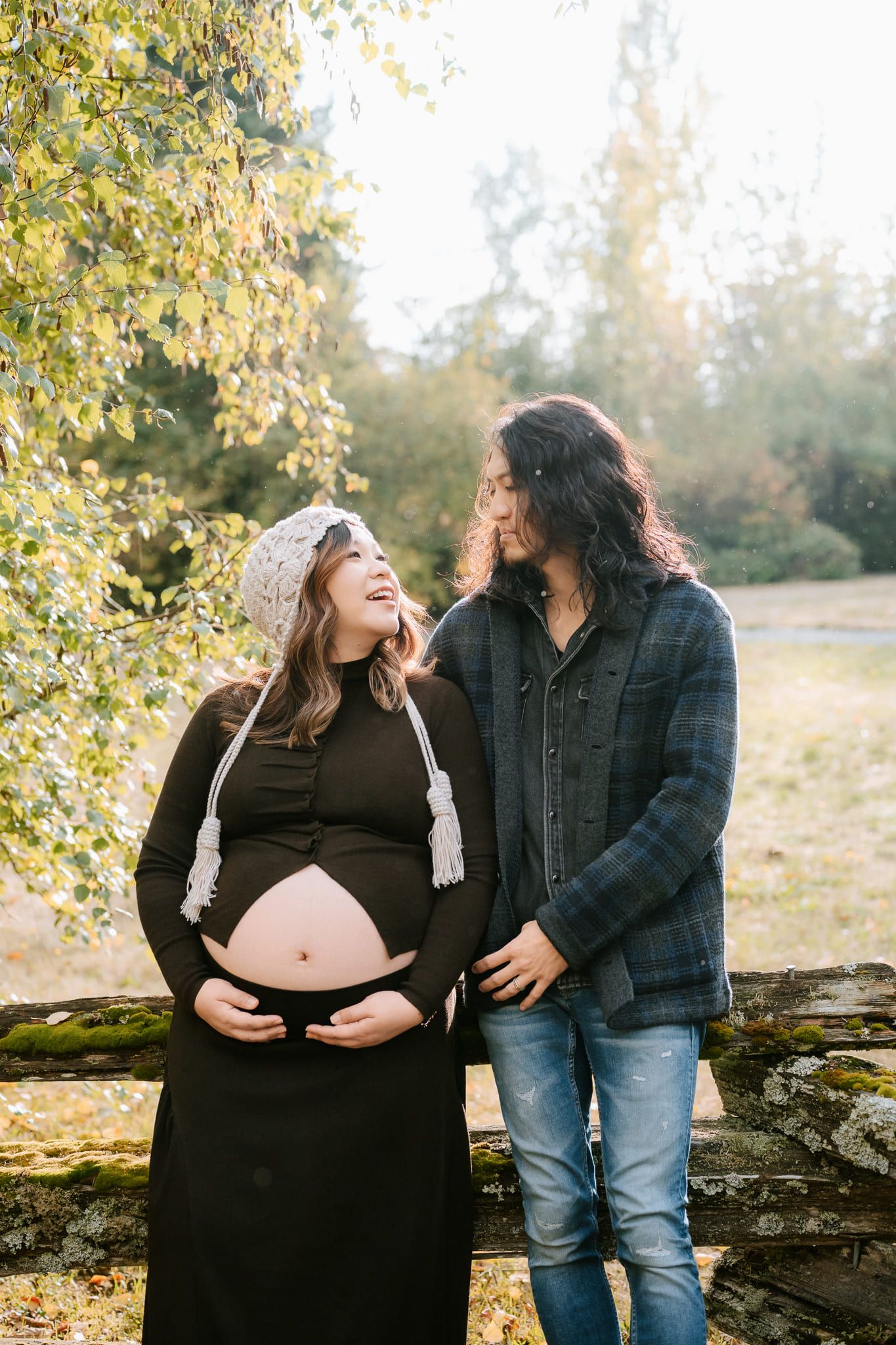 Outdoor fall maternity shoot among autumn trees in a park, expectant mother in black