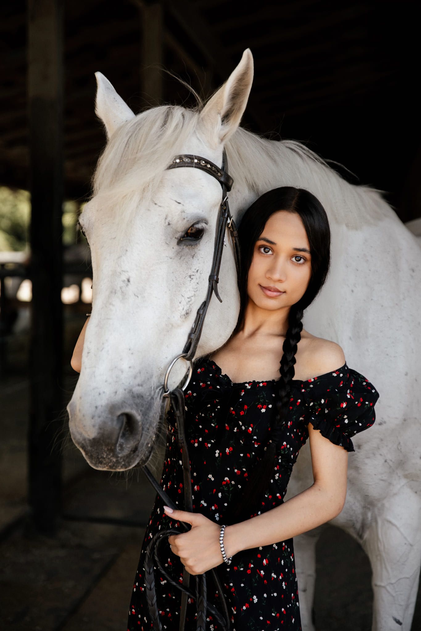 Horse portrait photography, young woman with braids standing beside a white horse