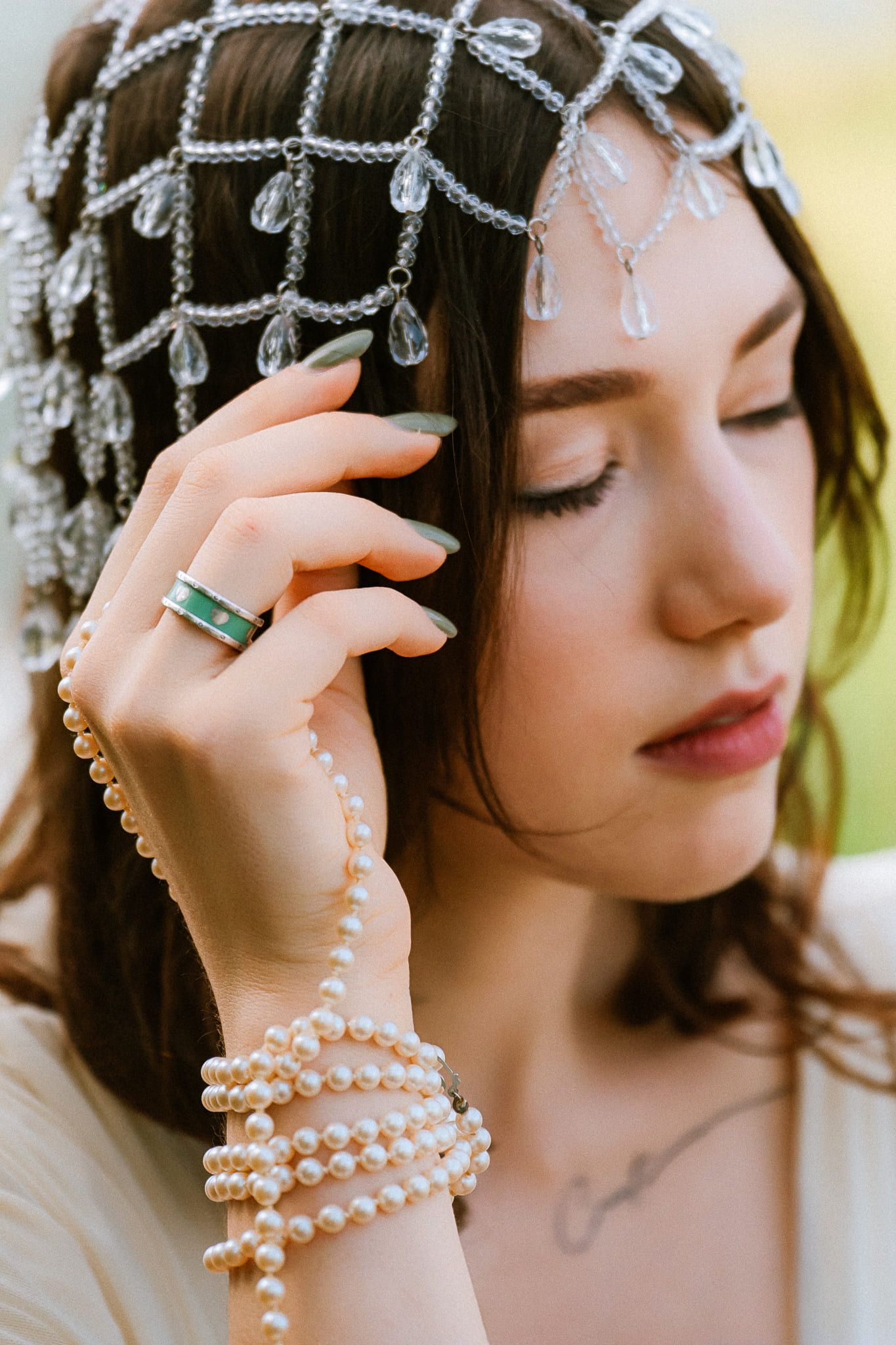 Classic portrait photography, woman in a crystal headpiece and pearls with her eyes closed